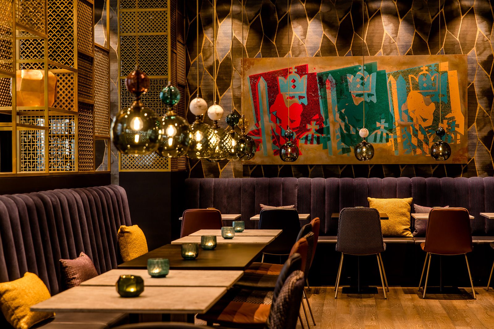 Hotel Aachen Motel One Innenbereich mit Tischen und Stühlen sowie Kunst an der Wand