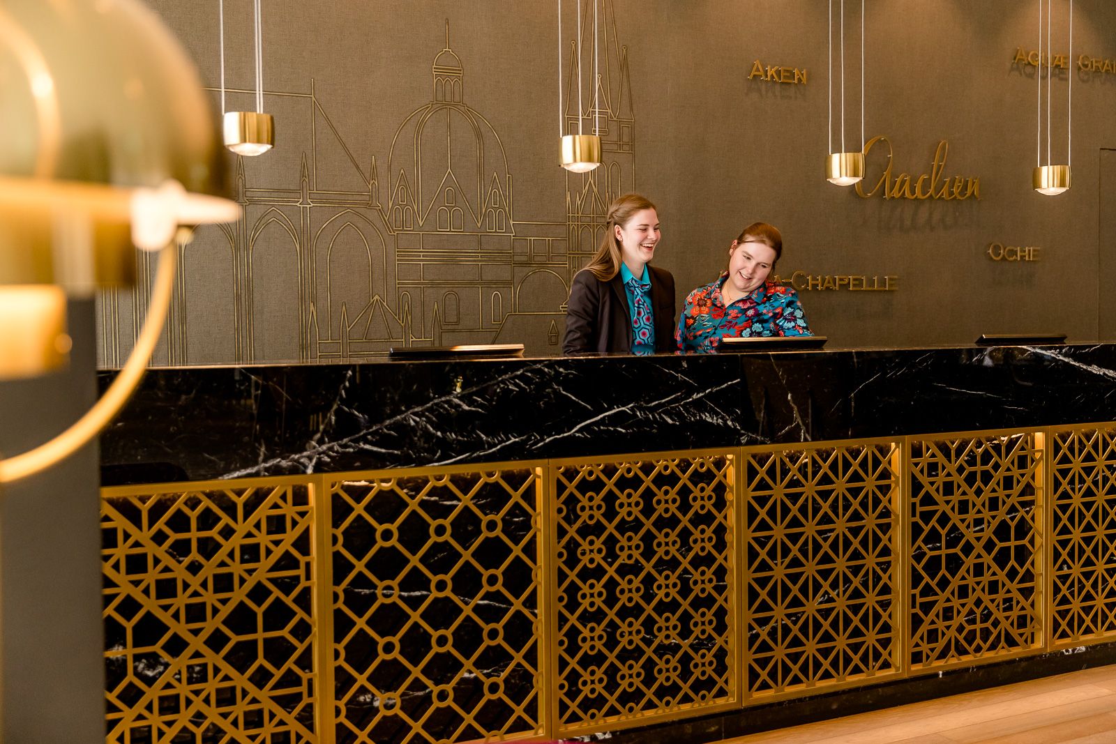 Hotel Aachen Motel One Rezeption mit zwei Mitarbeitenden