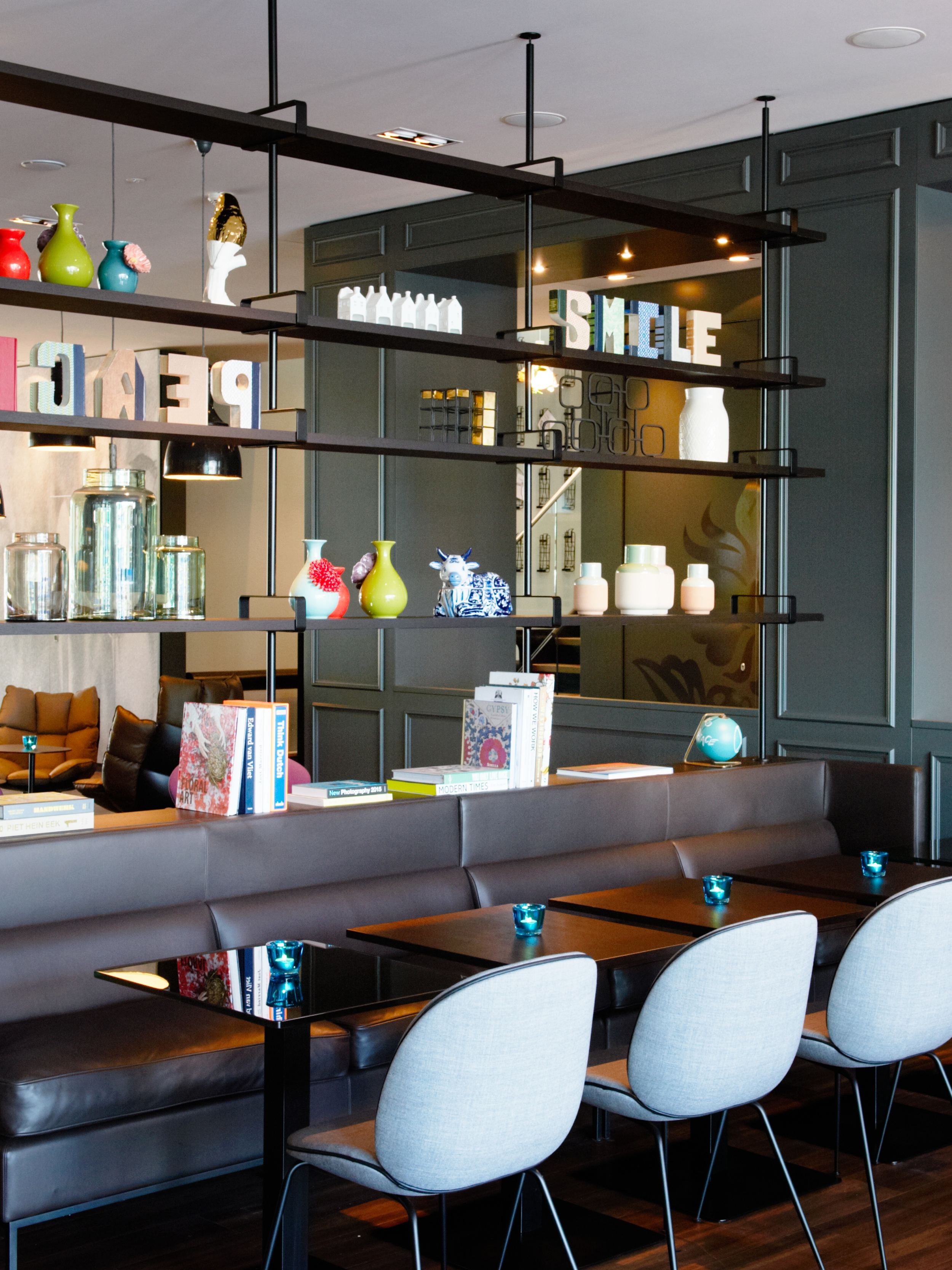 hotel Amsterdam Motel One indoor area with several tables and chairs