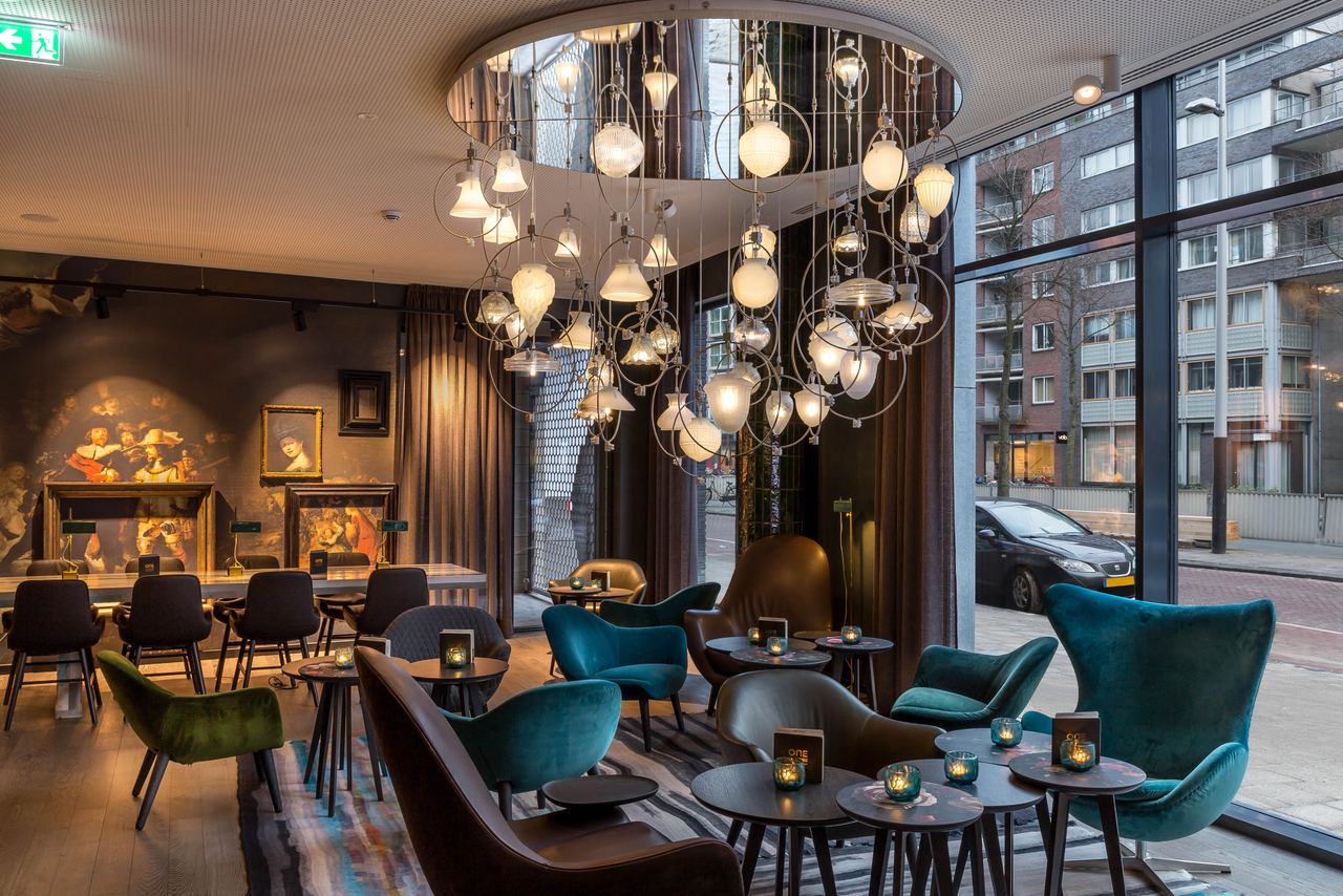 Hotel Amsterdam Waterlooplein Motel One Innenbereich mit mehreren Tischen und Stühlen