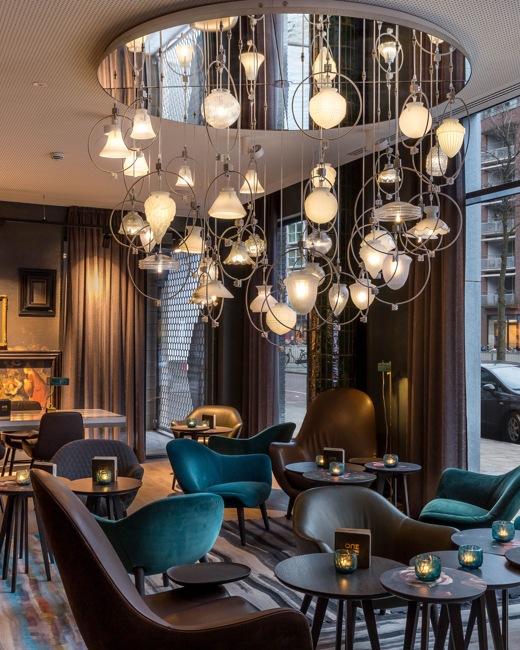 Hotel Amsterdam Waterlooplein Motel One Innenbereich mit mehreren Tischen und Stühlen