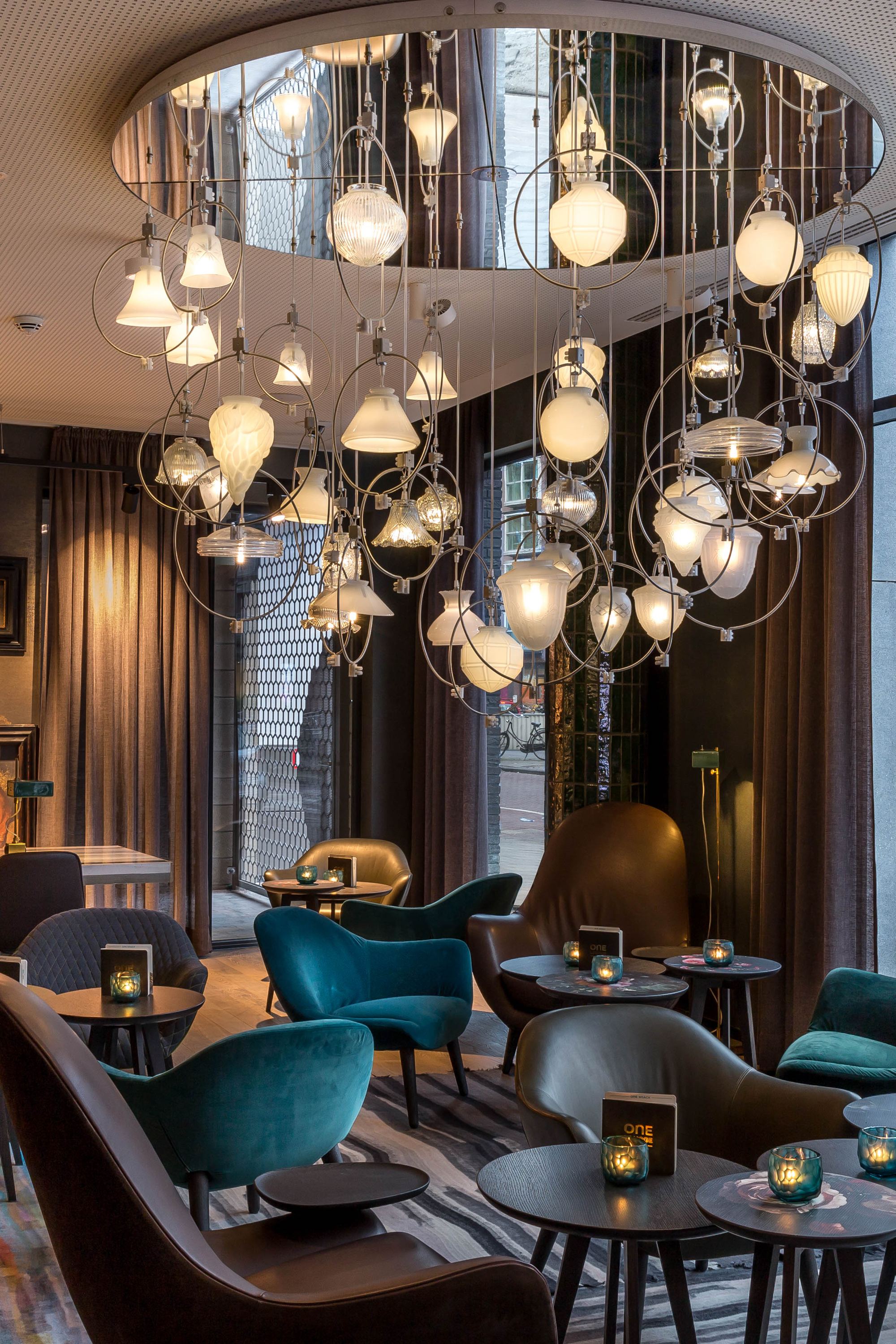 Hotel Amsterdam Waterlooplein Motel One Innenbereich mit mehreren Tischen und Stühlen