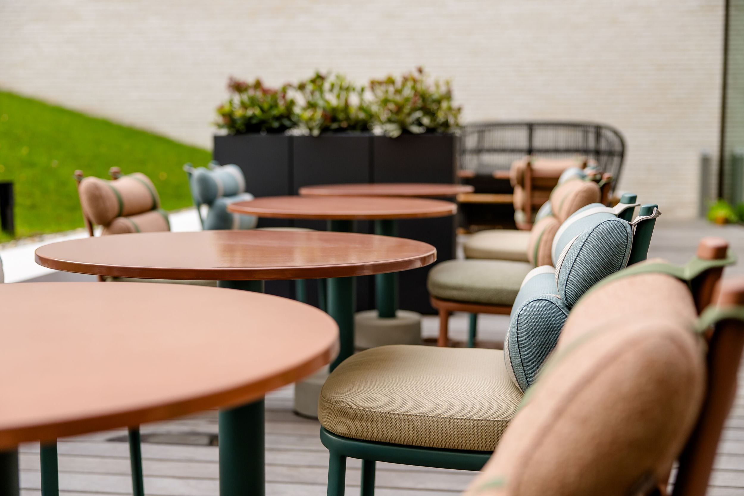 Hotel Antwerpen Motel One Außenbereich mit Nahaufnahme auf Tische und Stühle