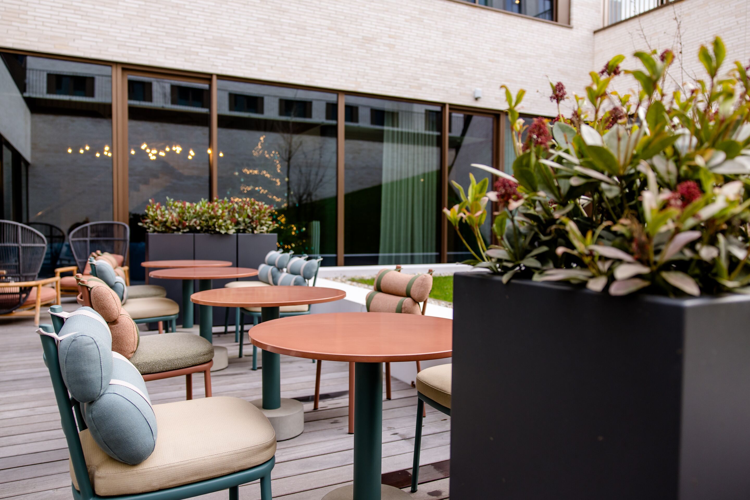 Hotel Antwerpen Motel One Außenbereich mit mehreren Sitzgelegenheiten auf großer Terrasse
