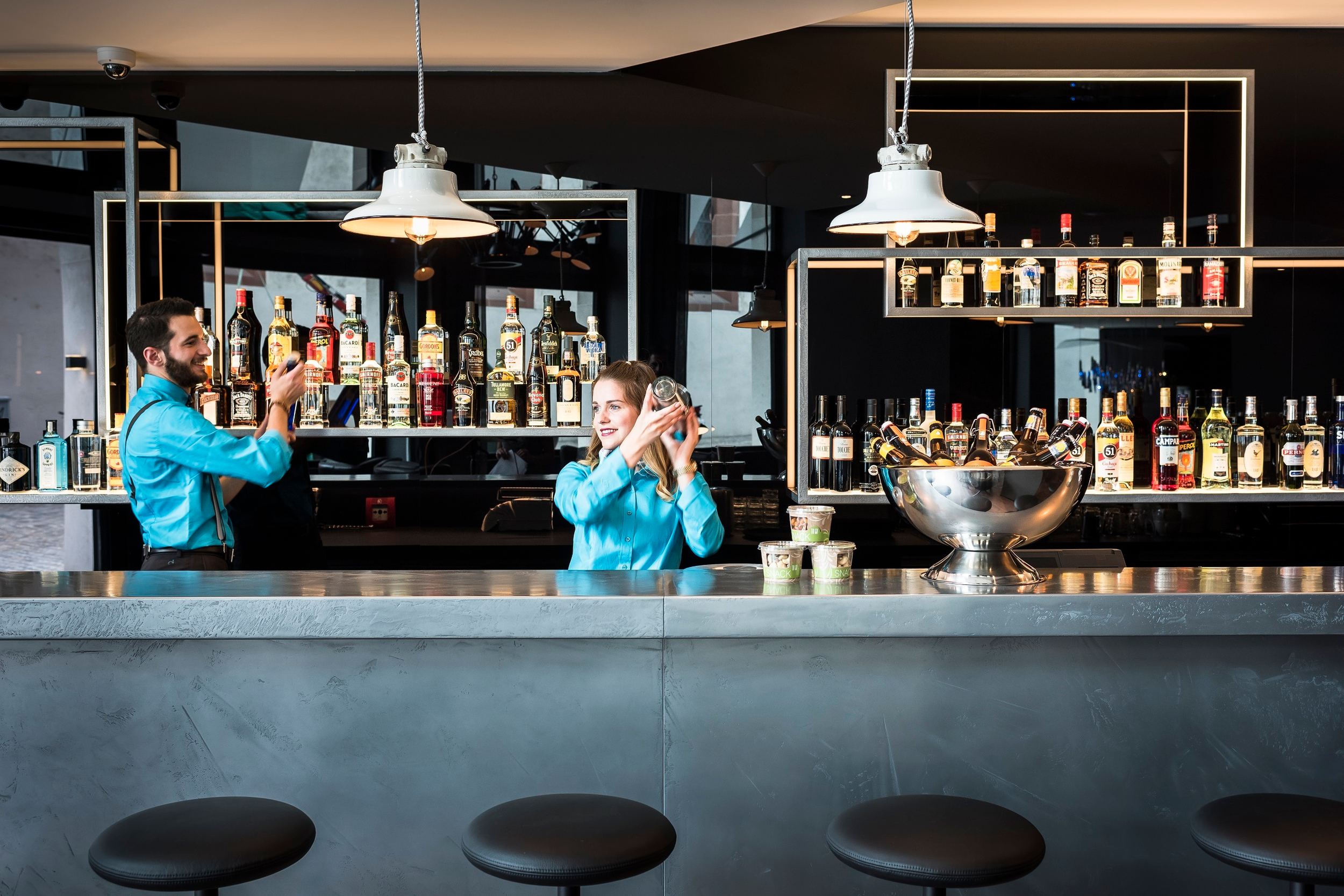 Designhotel Basel Motel One Bar mit zwei Mitarbeitenden bei dem Mixen von Cocktails