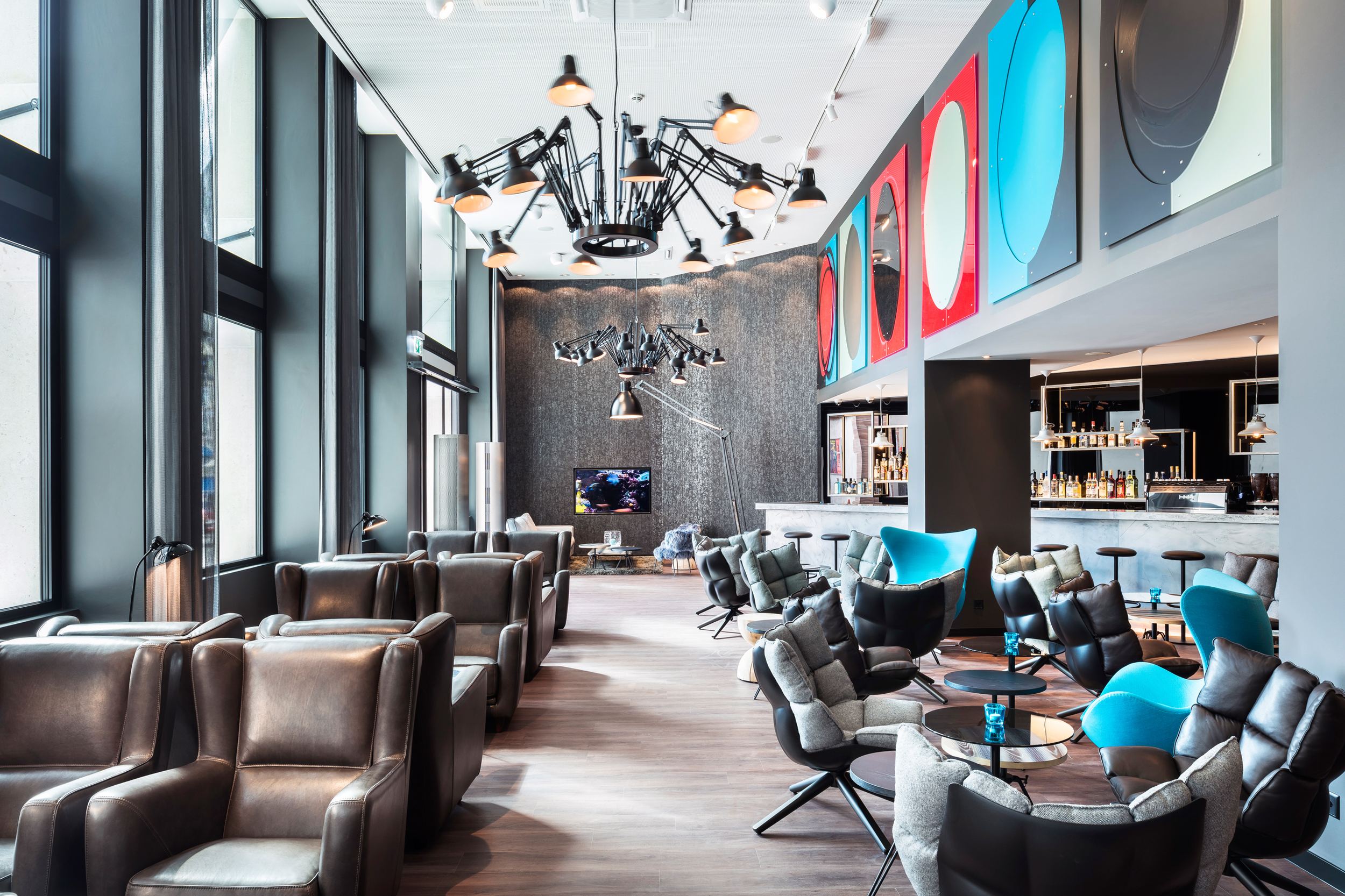 Designhotel Basel Motel One helle Lounge mit Sesseln zum Verweilen sowie die Bar