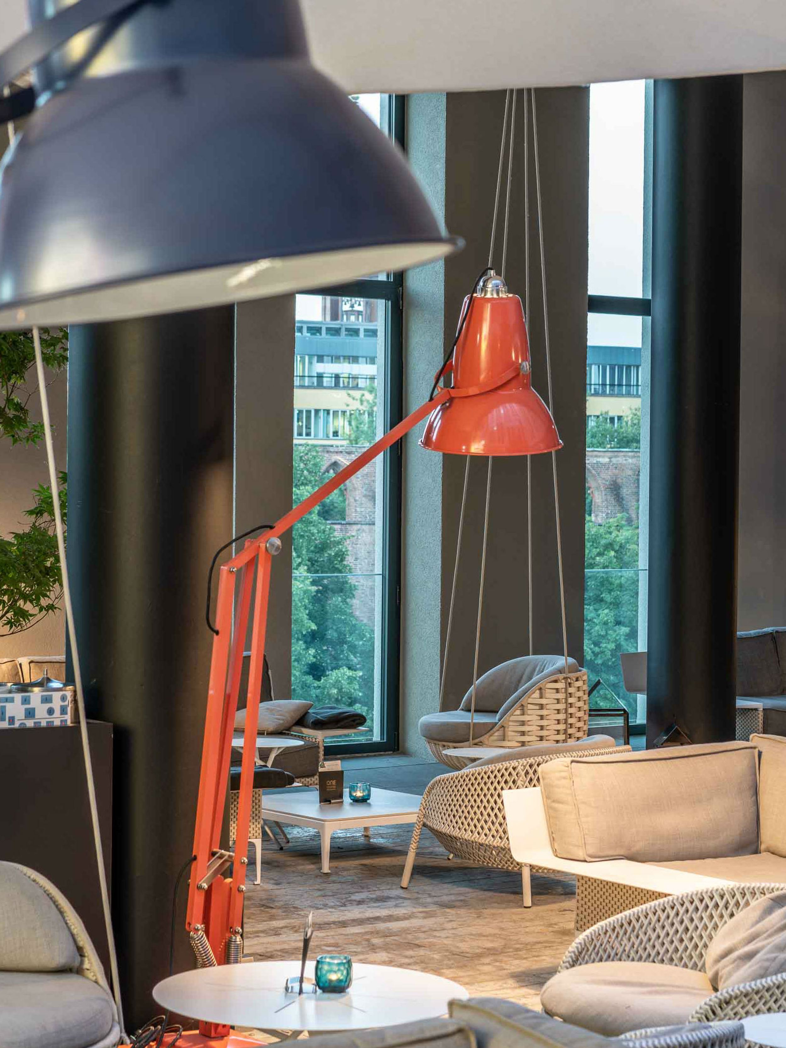 Hotel Berlin Alexanderplatz Motel One lichtdurchflutete Lounge mit mehreren Sitzgelegenheiten sowie schwingenden Stühlen, die an der Decke befestigt sind