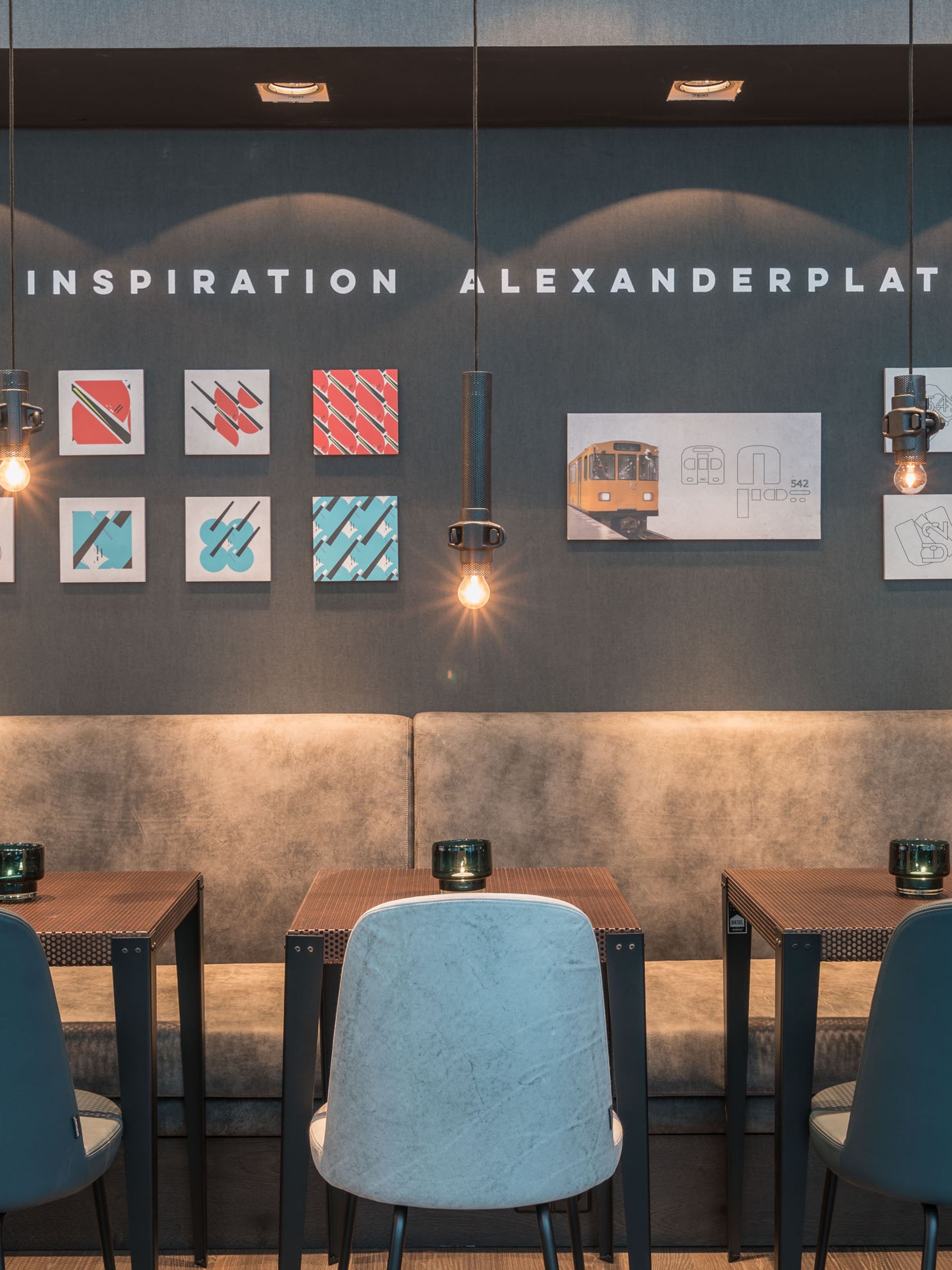 hotel Berlin Alexanderplatz Motel One dining area with several tables and chairs, as well as “Inspiration Alexanderplatz” lettering on the wall