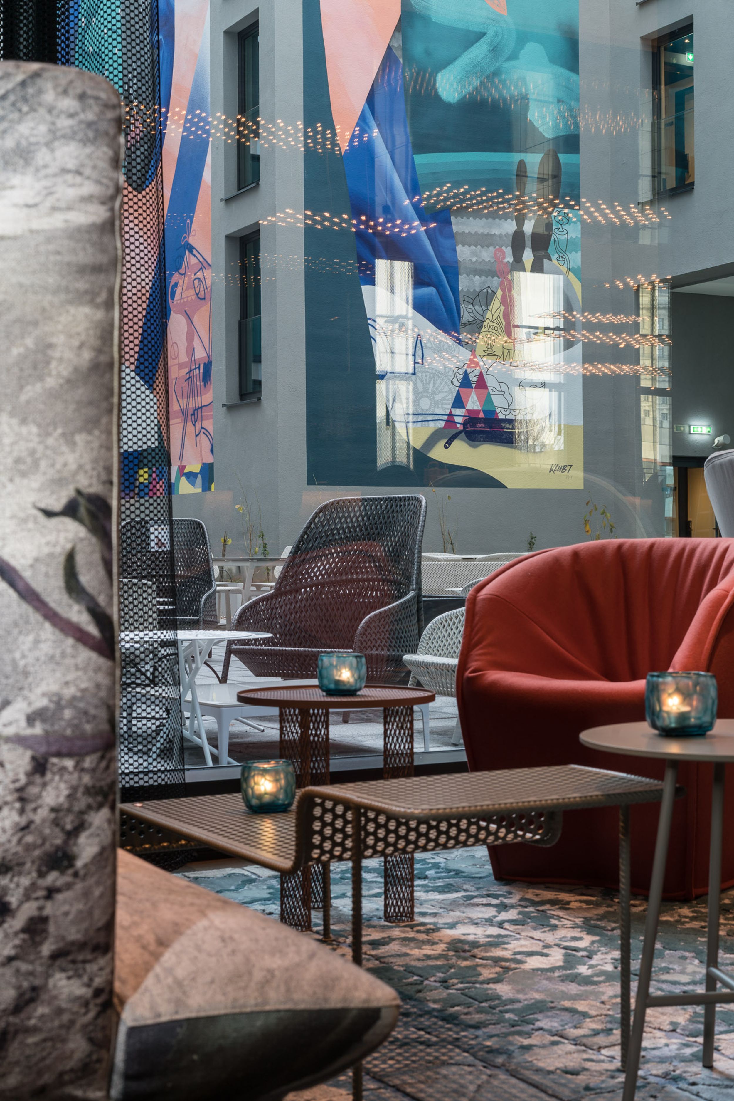 Designhotel Berlin Alexanderplatz Motel One Lounge mit Blick durch bodentiefe Fensterfront auf den Außenbereich des Hotels mit Sitzgelegenheiten