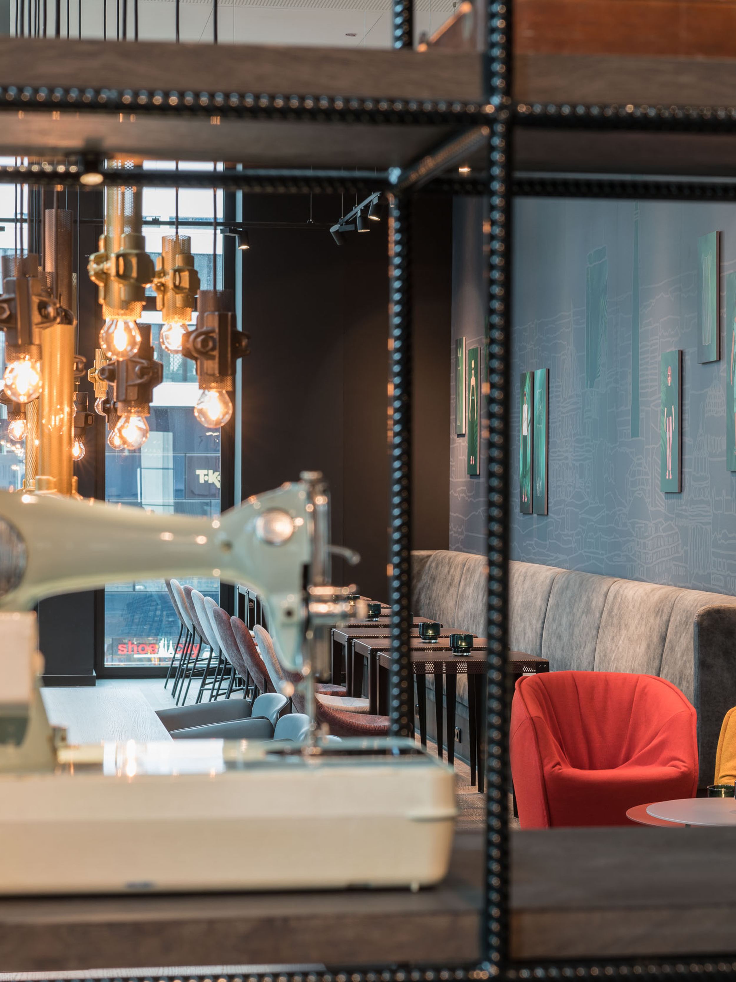 hotel Berlin Alexanderplatz Motel One lounge with seating and view of a sewing machine in the foreground on an open shelf