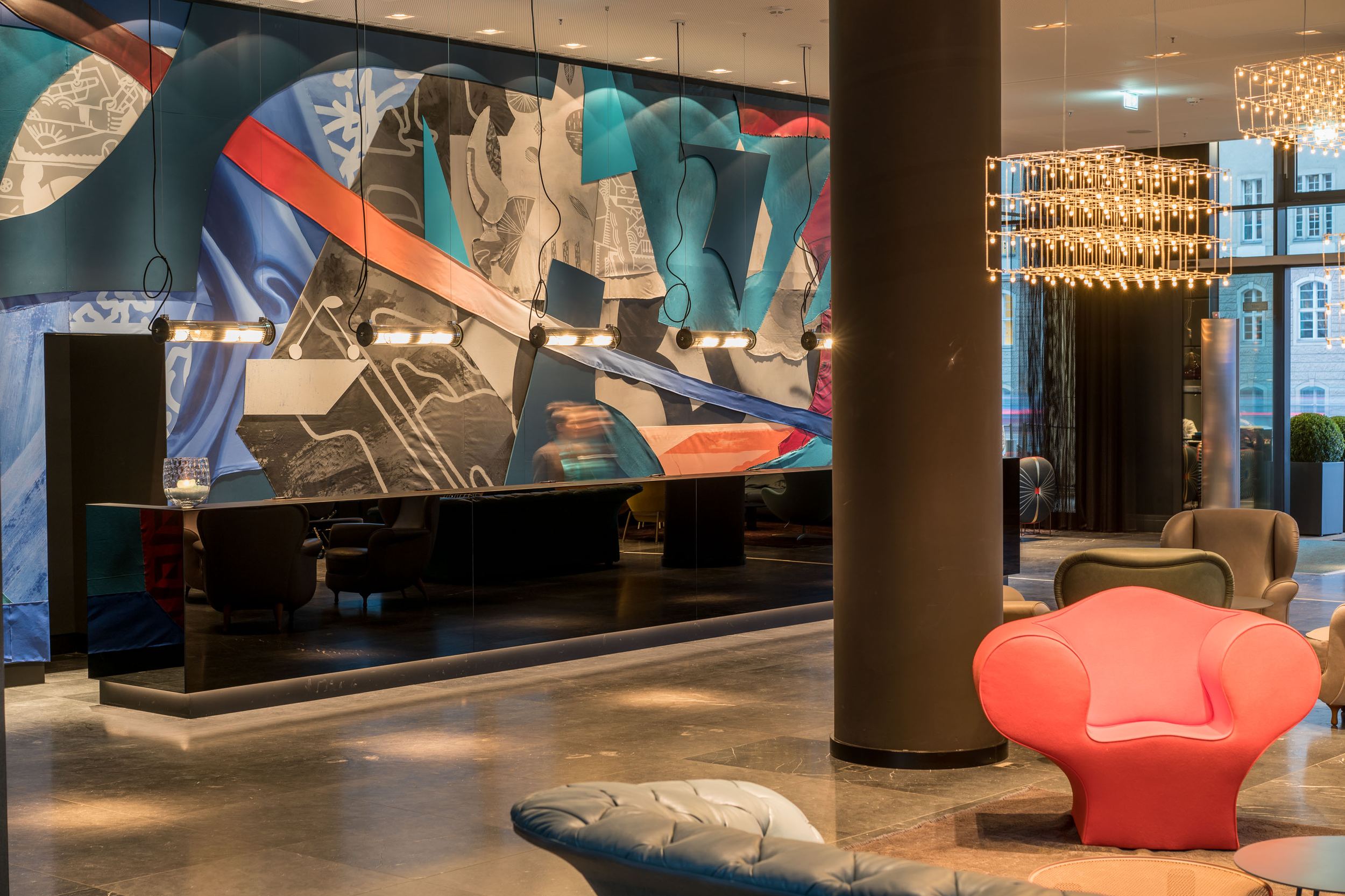 hotel Berlin Alexanderplatz Motel One bright entrance area with armchairs and reception desk with black front