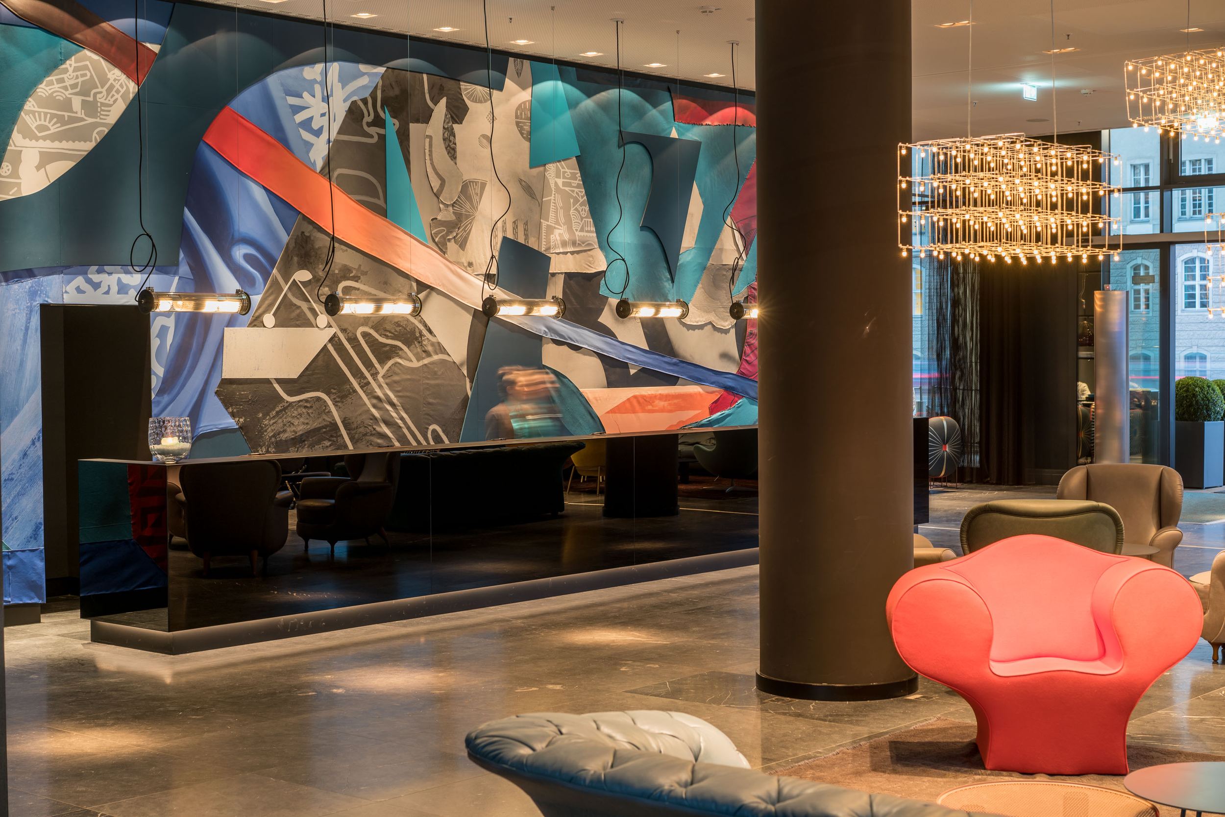 Hotel Berlin Alexanderplatz Motel One heller Eingangsbereich mit Sesseln und Rezeption mit schwarzer Front