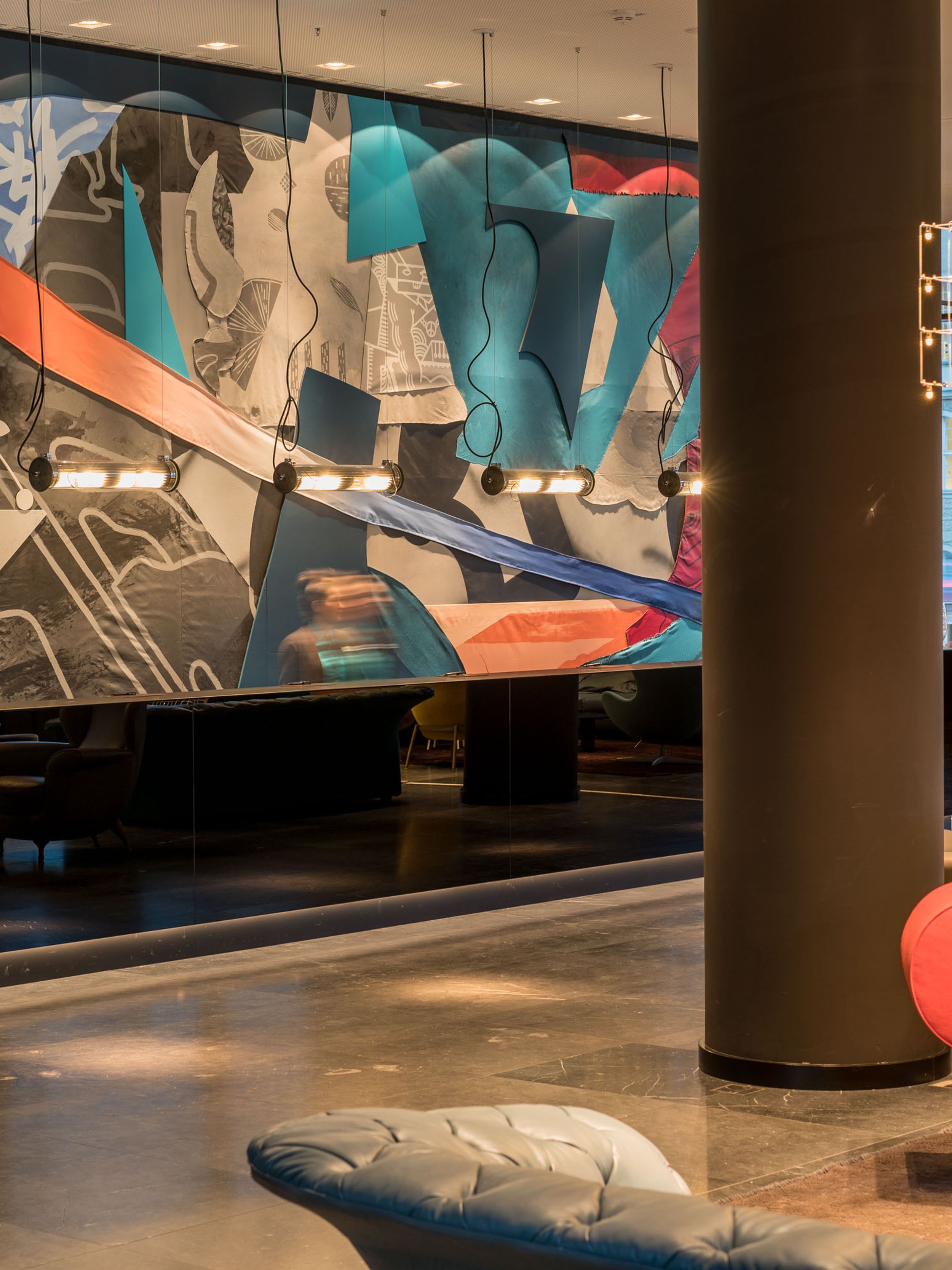 Hotel Berlin Alexanderplatz Motel One heller Eingangsbereich mit Sesseln und Rezeption mit schwarzer Front