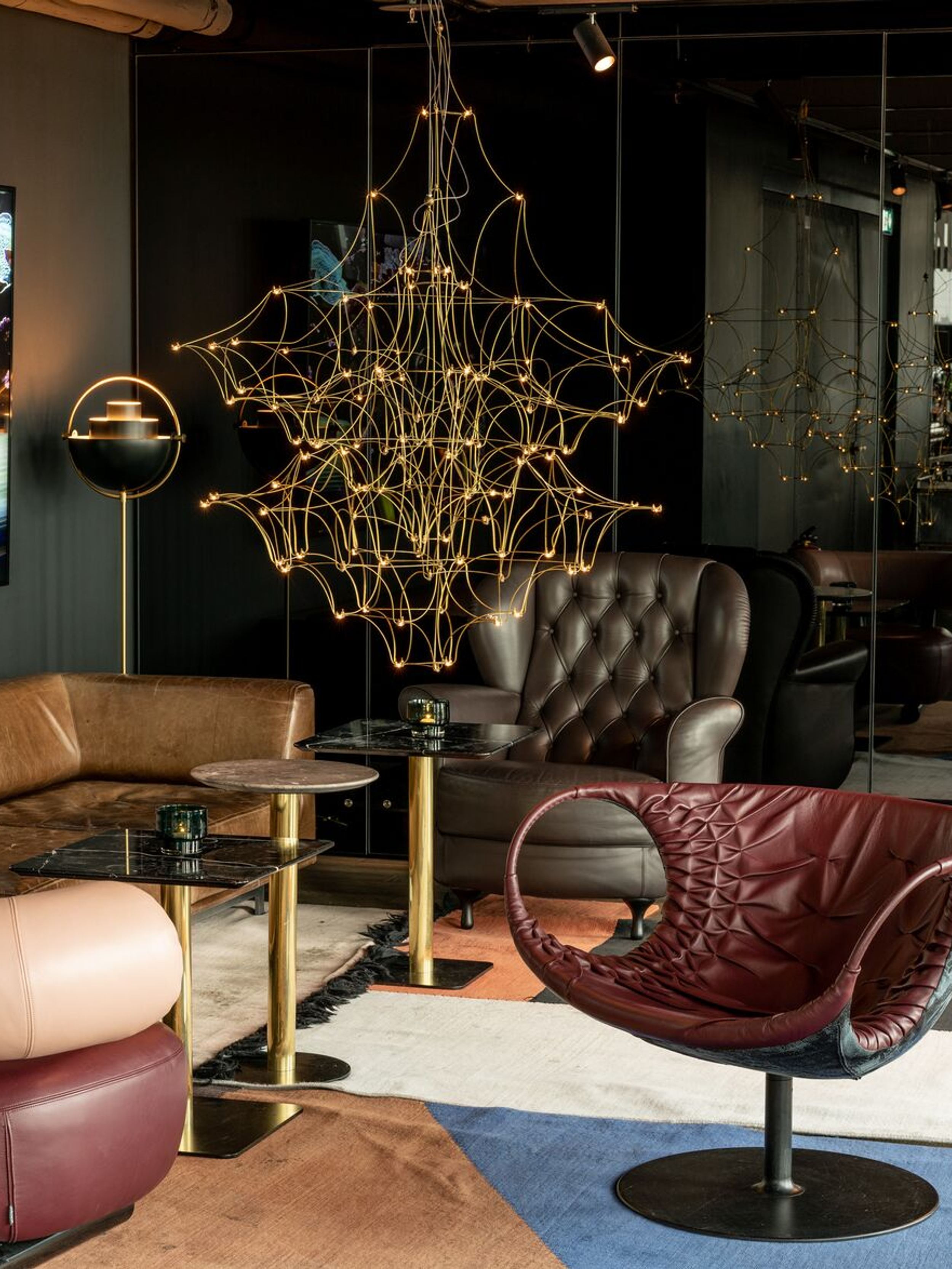 hotel Berlin Alexanderplatz Motel One bright lounge with a view of a seating area consisting of a sofa and three armchairs, as well as a TV on the wall