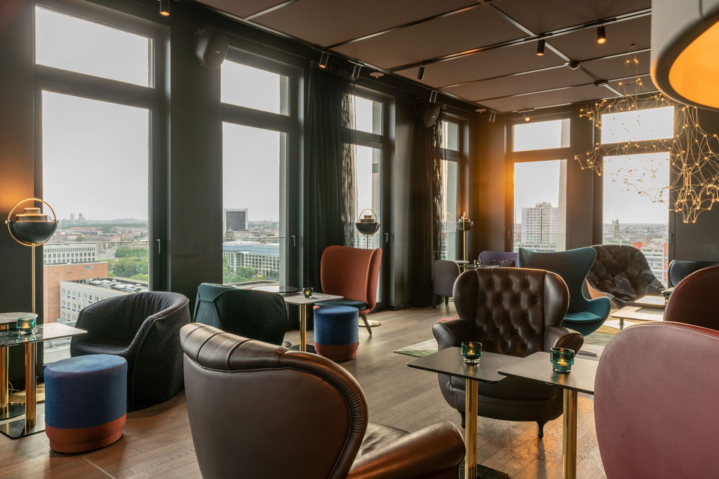 Hotel Berlin Alexanderplatz Motel One lichtdurchflutete Lounge mit vielen bodentiefen Fenstern und Ausblick über die Stadt