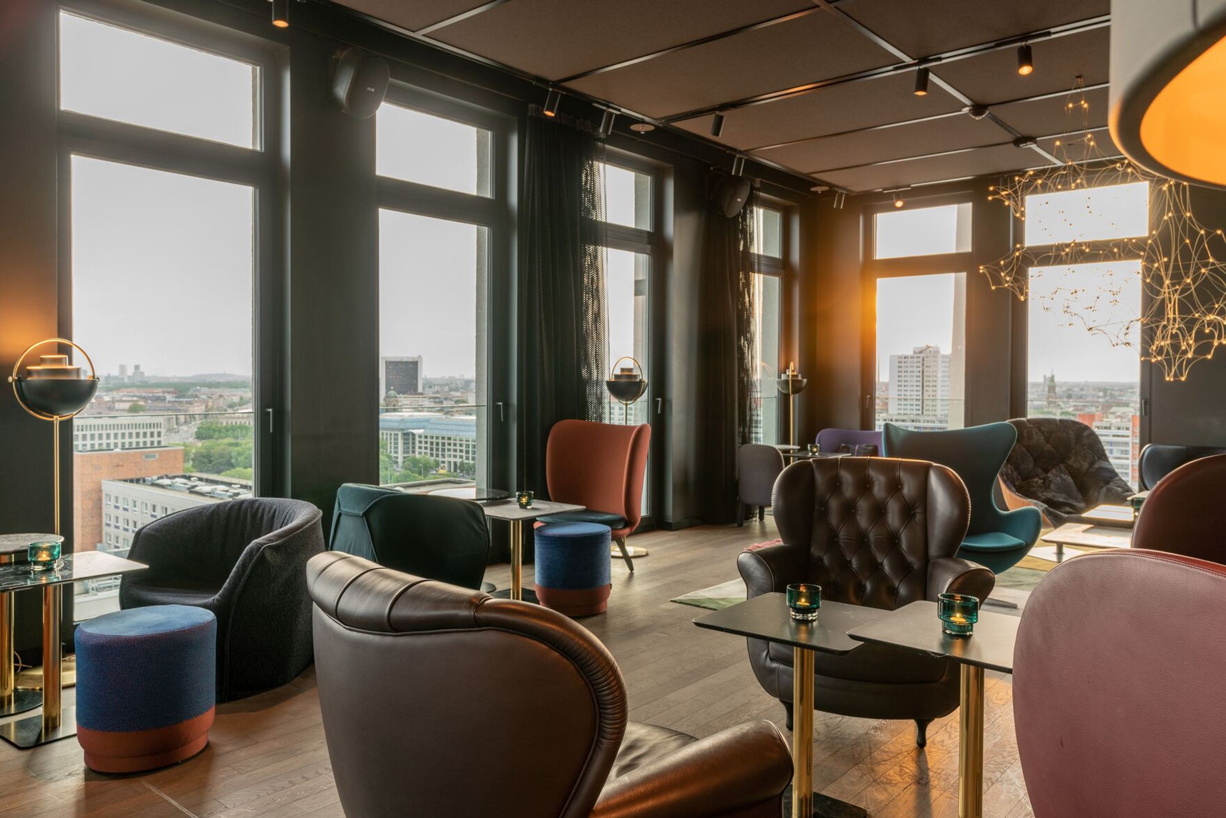 Hotel Berlin Alexanderplatz Motel One lichtdurchflutete Lounge mit vielen bodentiefen Fenstern und Ausblick über die Stadt