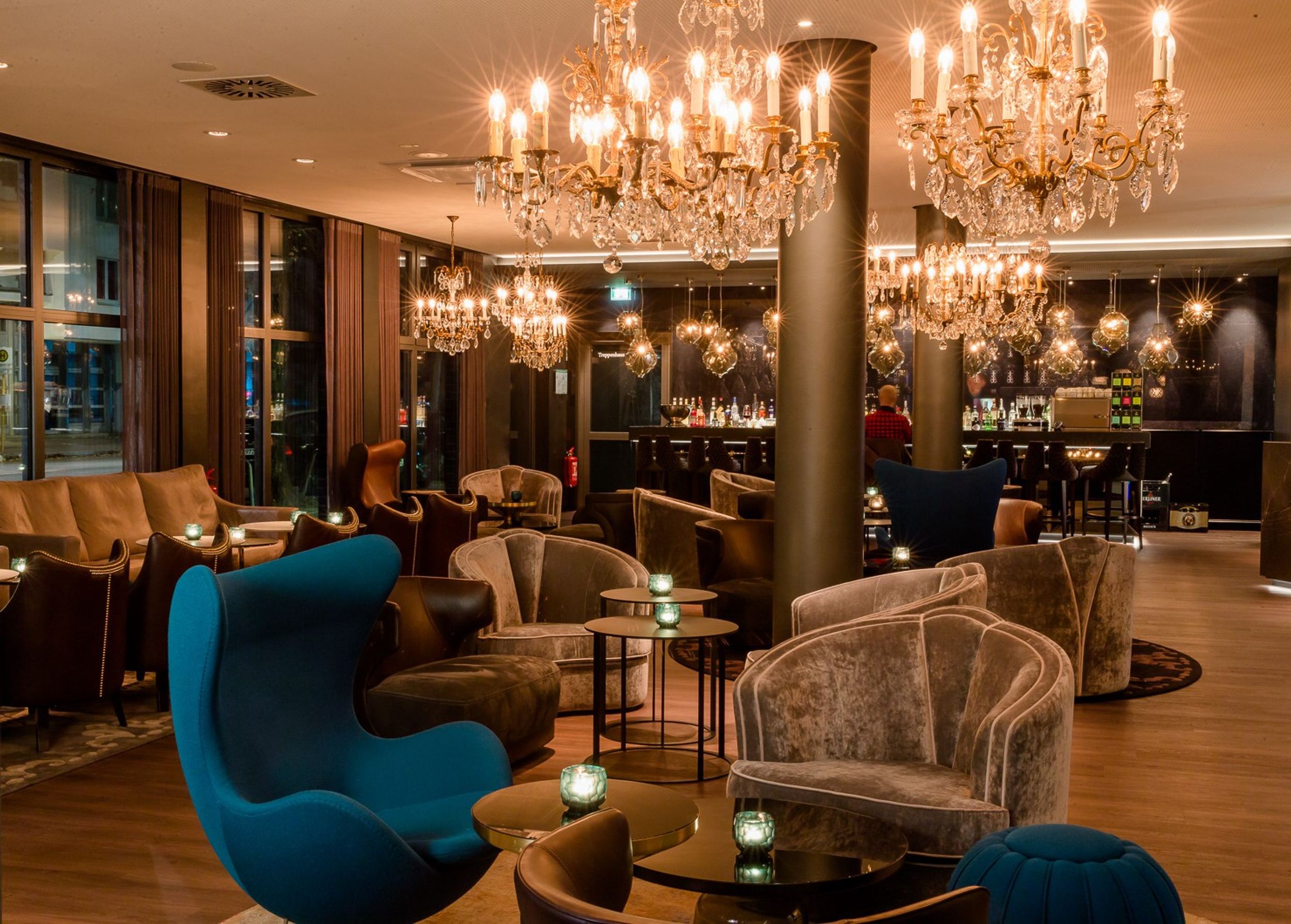 Designhotel Berlin Bellevue Motel One große Lounge mit mehreren Sitzgelegenheiten sowie Bar im Hintergrund