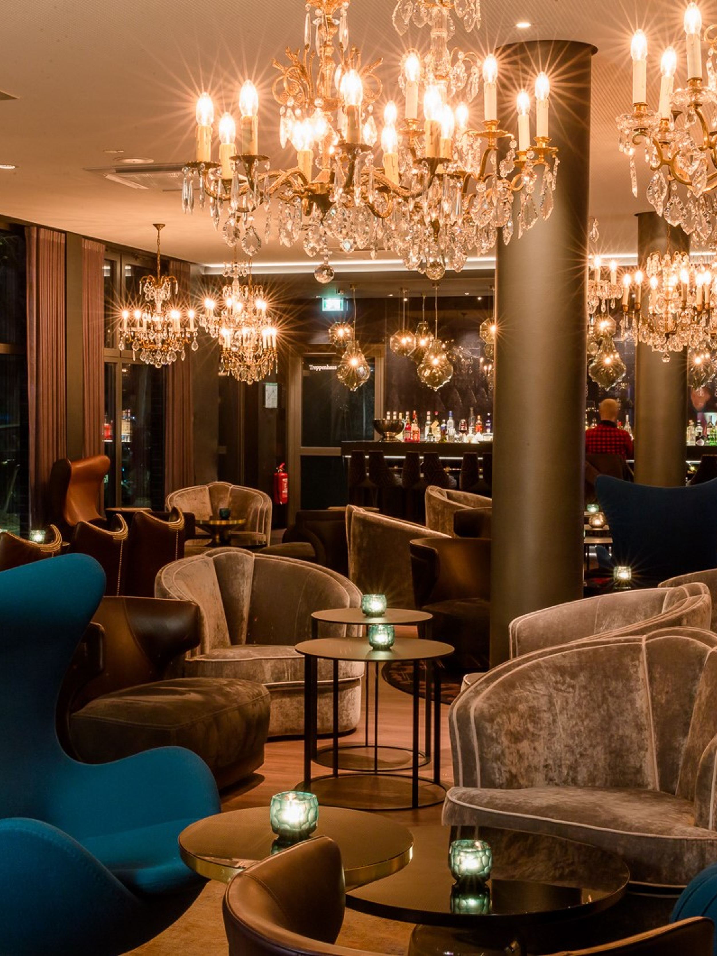 Designhotel Berlin Bellevue Motel One große Lounge mit mehreren Sitzgelegenheiten sowie Bar im Hintergrund
