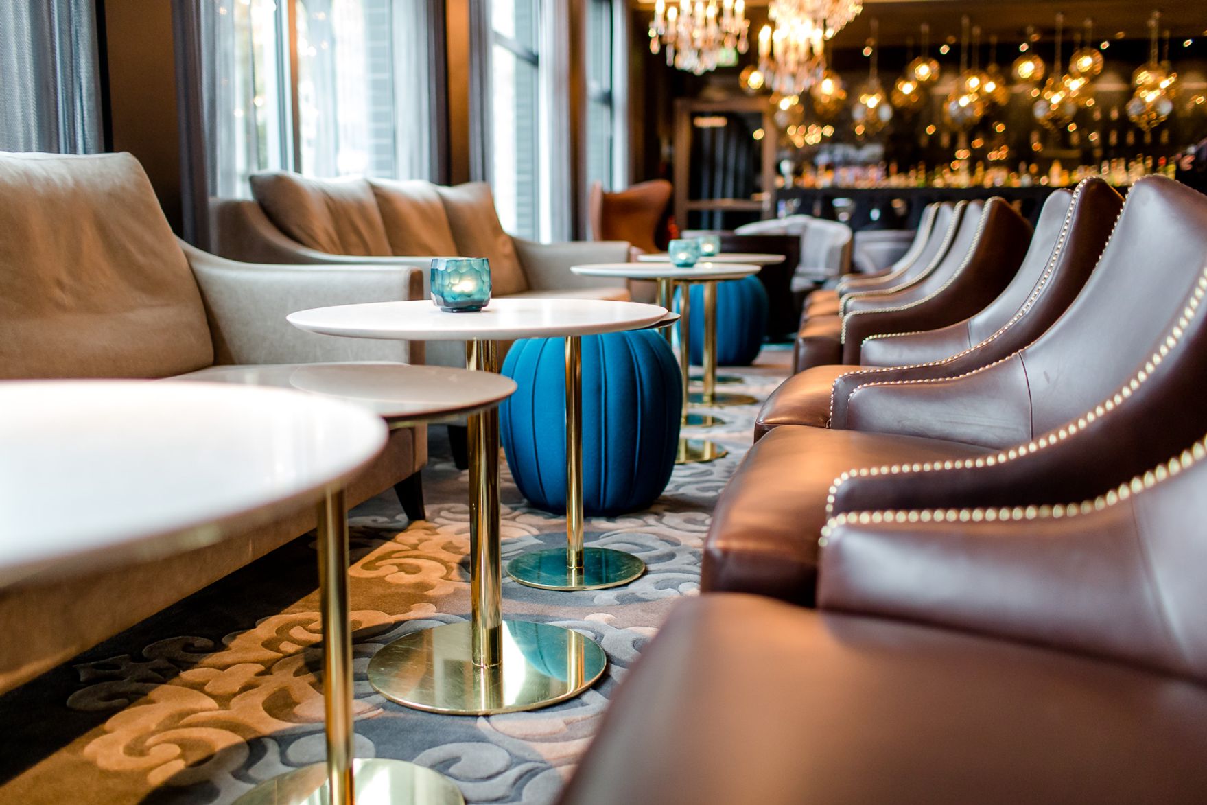 Hotel Berlin Bellevue Motel One lichtdurchflutete Lounge mit mehreren Tischen und Stühlen sowie Bar im Hintergrund