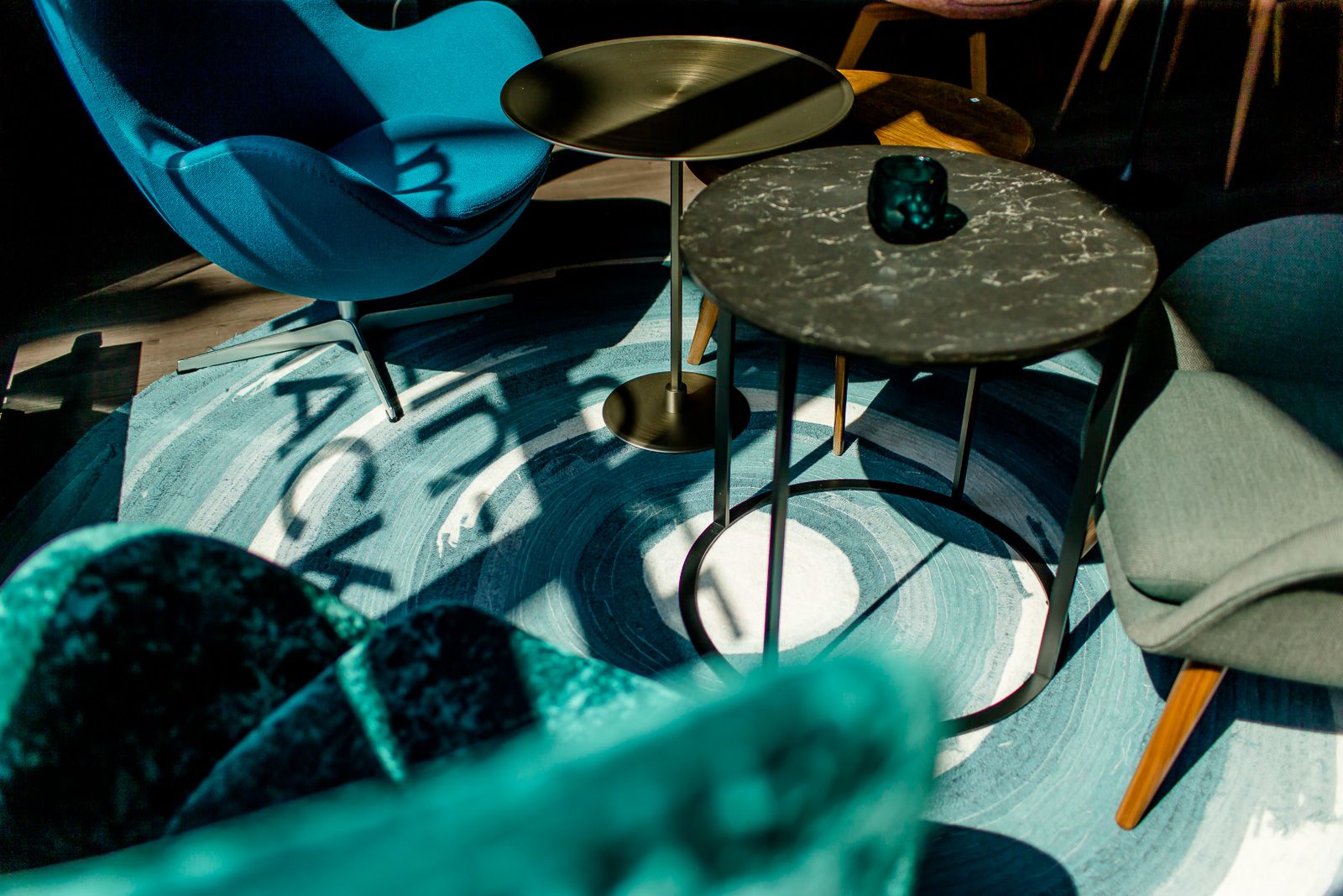 Hotel Berlin Hackescher Markt Motel One Lounge mit Nahaufnahme auf eine Sitzgruppe mit schwarzem Beistelltisch und hellblau gemustertem Teppich