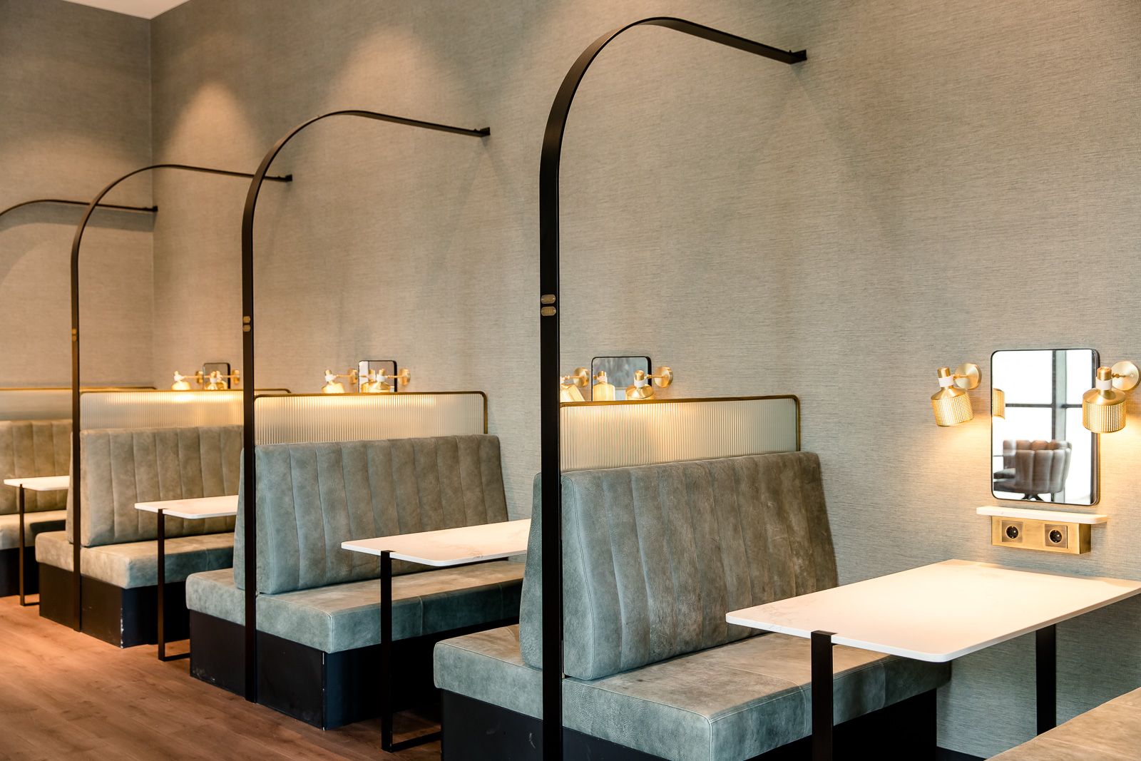 hotel Berlin Hauptbahnhof Motel One modern seating niches in the breakfast area with upholstered benches, white tables, and gold-colored wall lamps