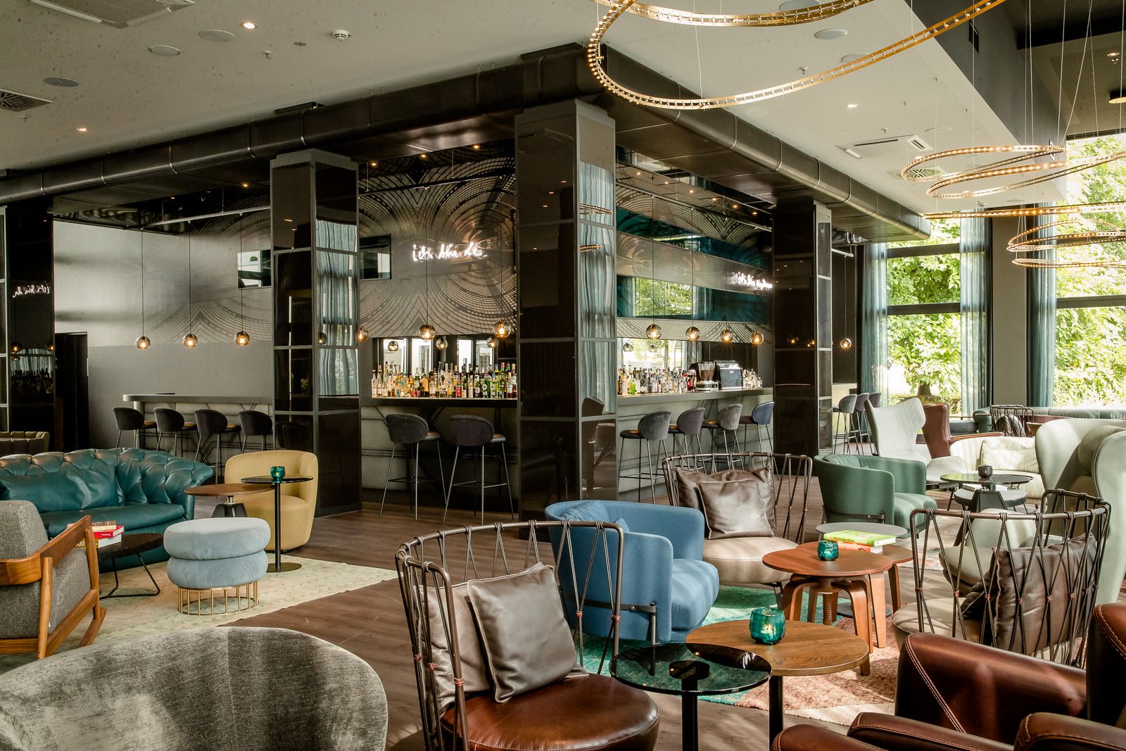 designhotel Berlin Hauptbahnhof Motel One light-filled lounge with armchairs and side tables, as well as a large corner bar