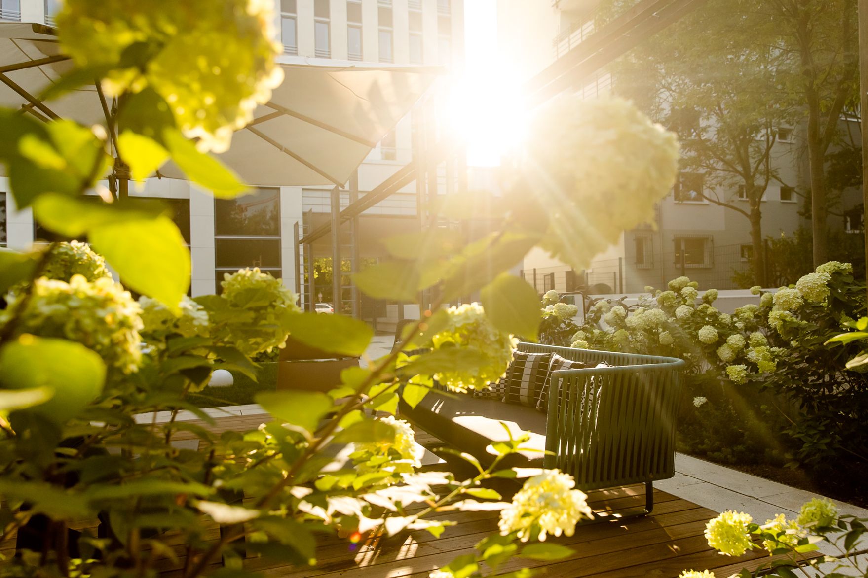 Hotel Berlin Hauptbahnhof Motel Außenbereich bei strahlendem Sonnenschein mit mehreren Sitzgelegenheiten