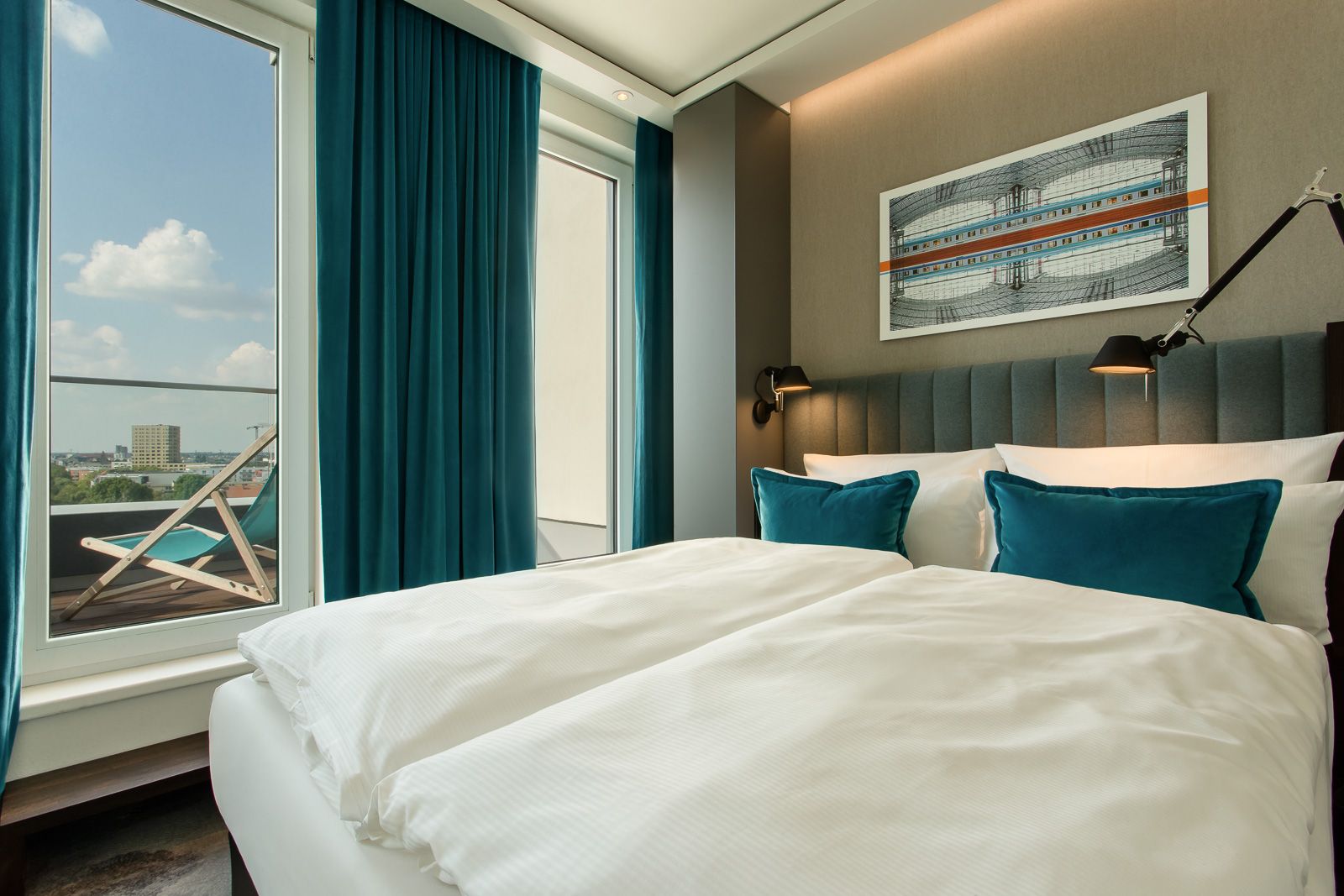 hotel Berlin Hauptbahnhof Motel One bright balcony room with double bed and view of a deck chair on the balcony