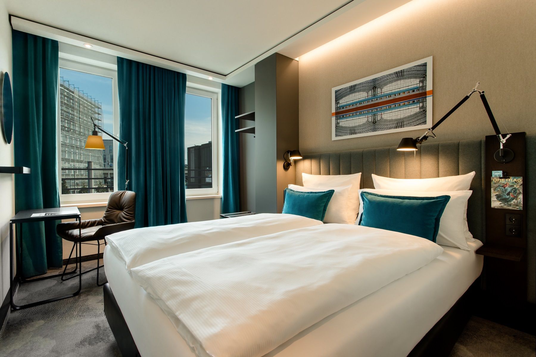 Hotel Berlin Hauptbahnhof Motel One helles Zimmer mit geräumigem Doppelbett sowie Tisch, Stuhl und runder Spiegel an der Wand