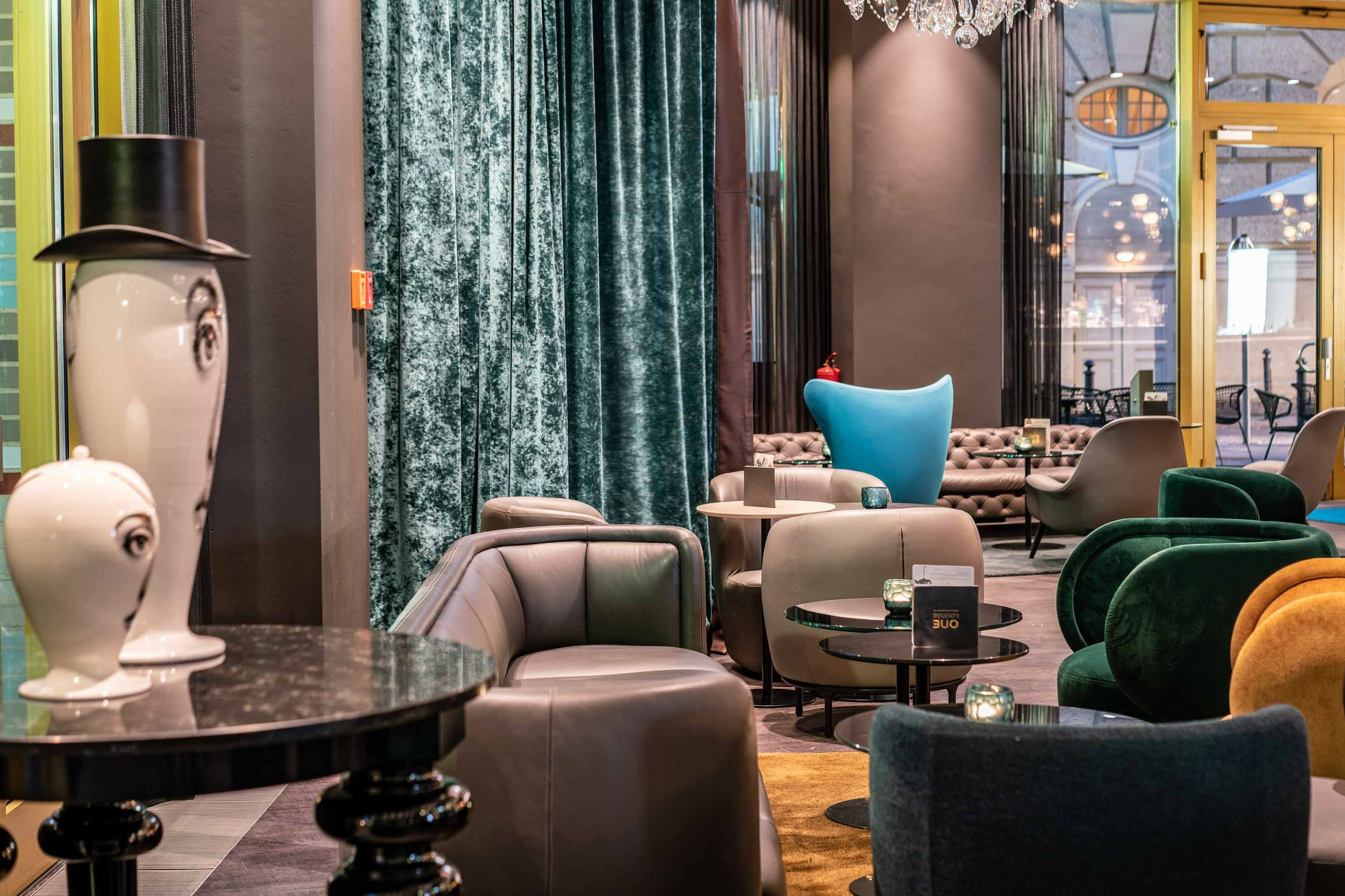 Designhotel Berlin Ku’damm Motel One große Lounge mit mehreren Sesseln und Beistelltischen zum Verweilen
