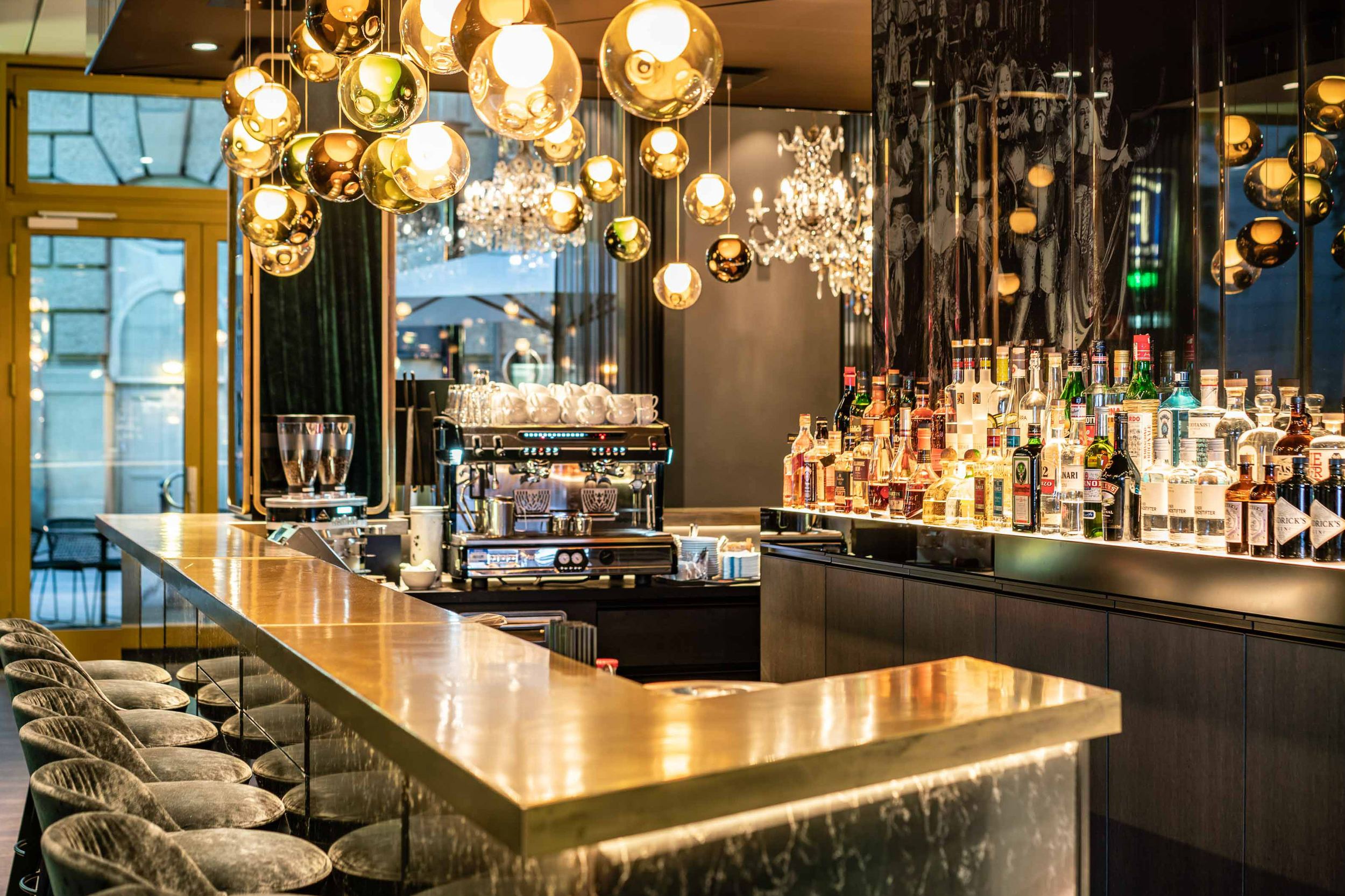 Hotel Berlin Ku’damm Motel One große Bar mit heller Beleuchtung und Barhockern an dem Tresen