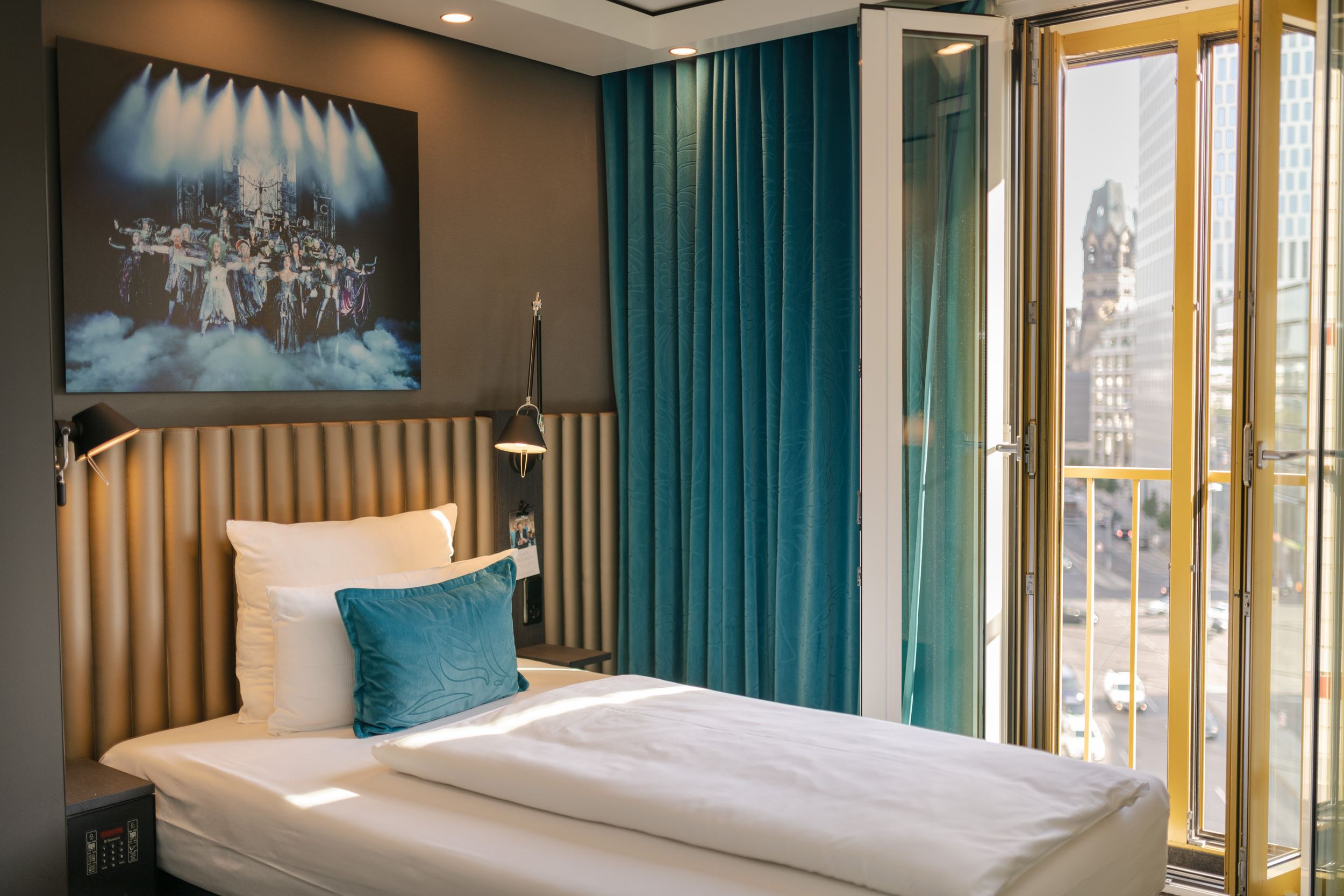Hotel Berlin Ku’damm Motel One seitlicher Blick auf ein gemütliches Einzelbett und ein offenes bodentiefes Fenster