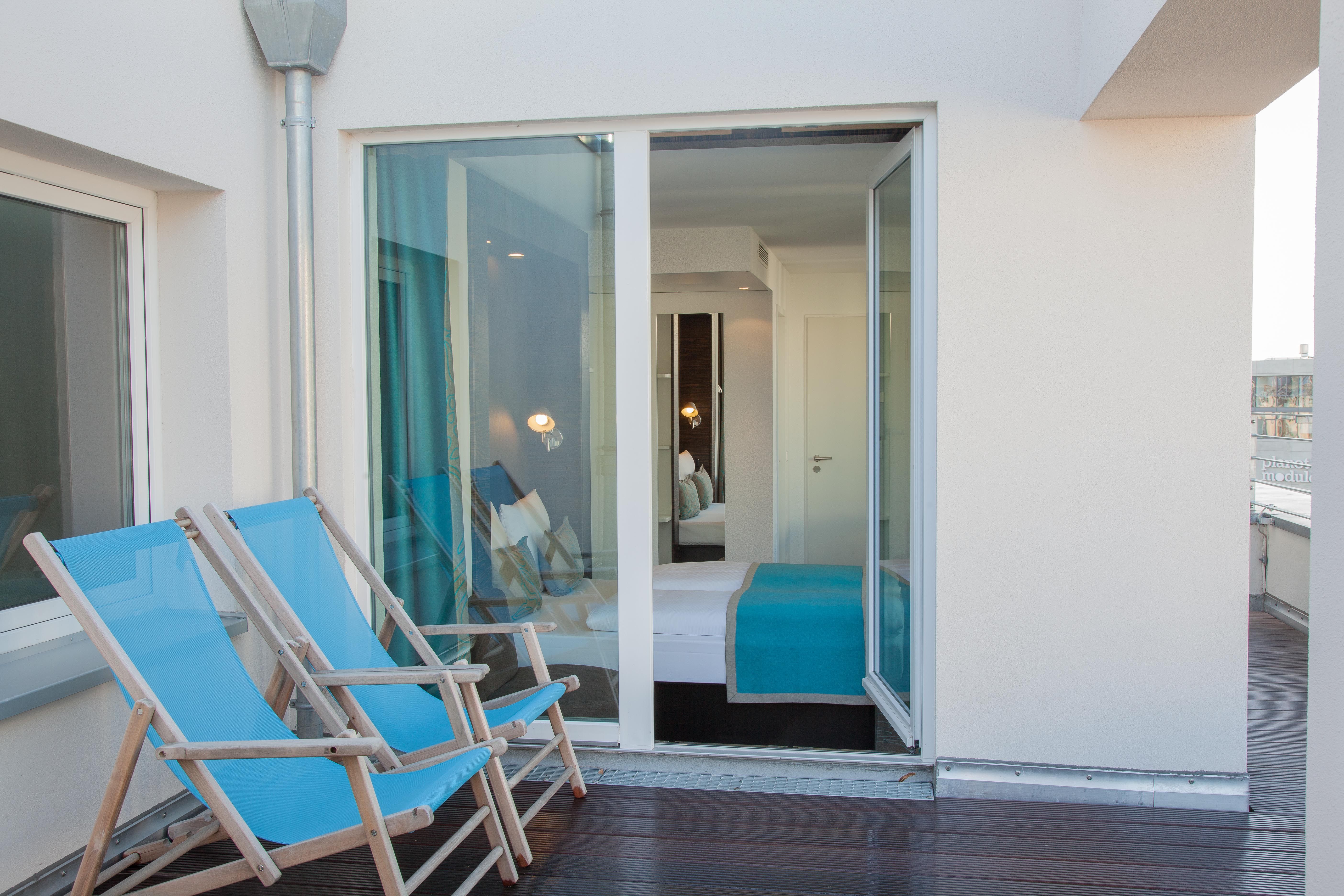 hotel Berlin Mitte Motel One balcony room with a view from the balcony of two deck chairs and the open balcony door into the room with a double bed