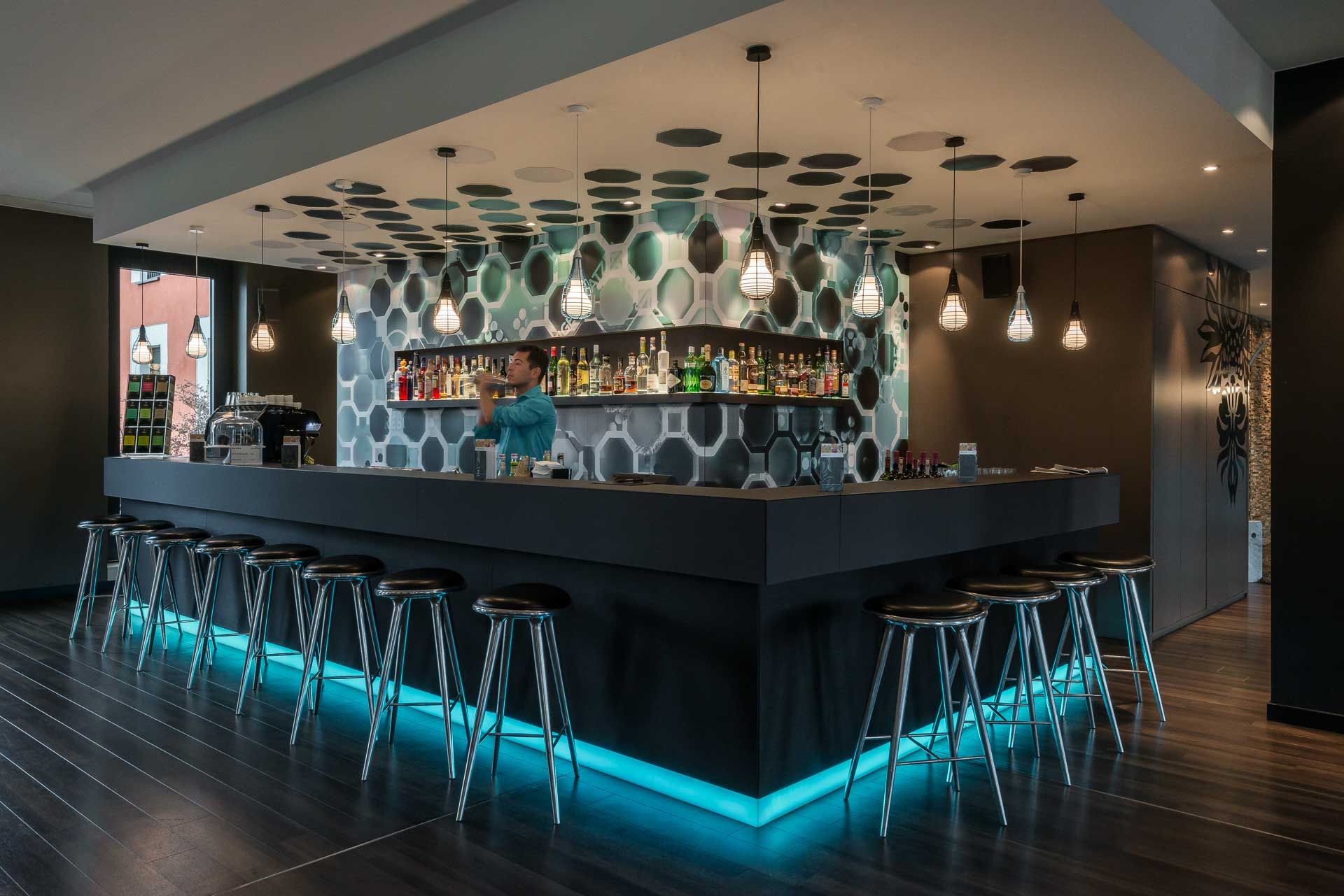 Hotel Berlin Potsdamer Platz Motel One Bar mit mehreren Barhockern sowie einem Barkeeper beim Shaken eines Cocktails