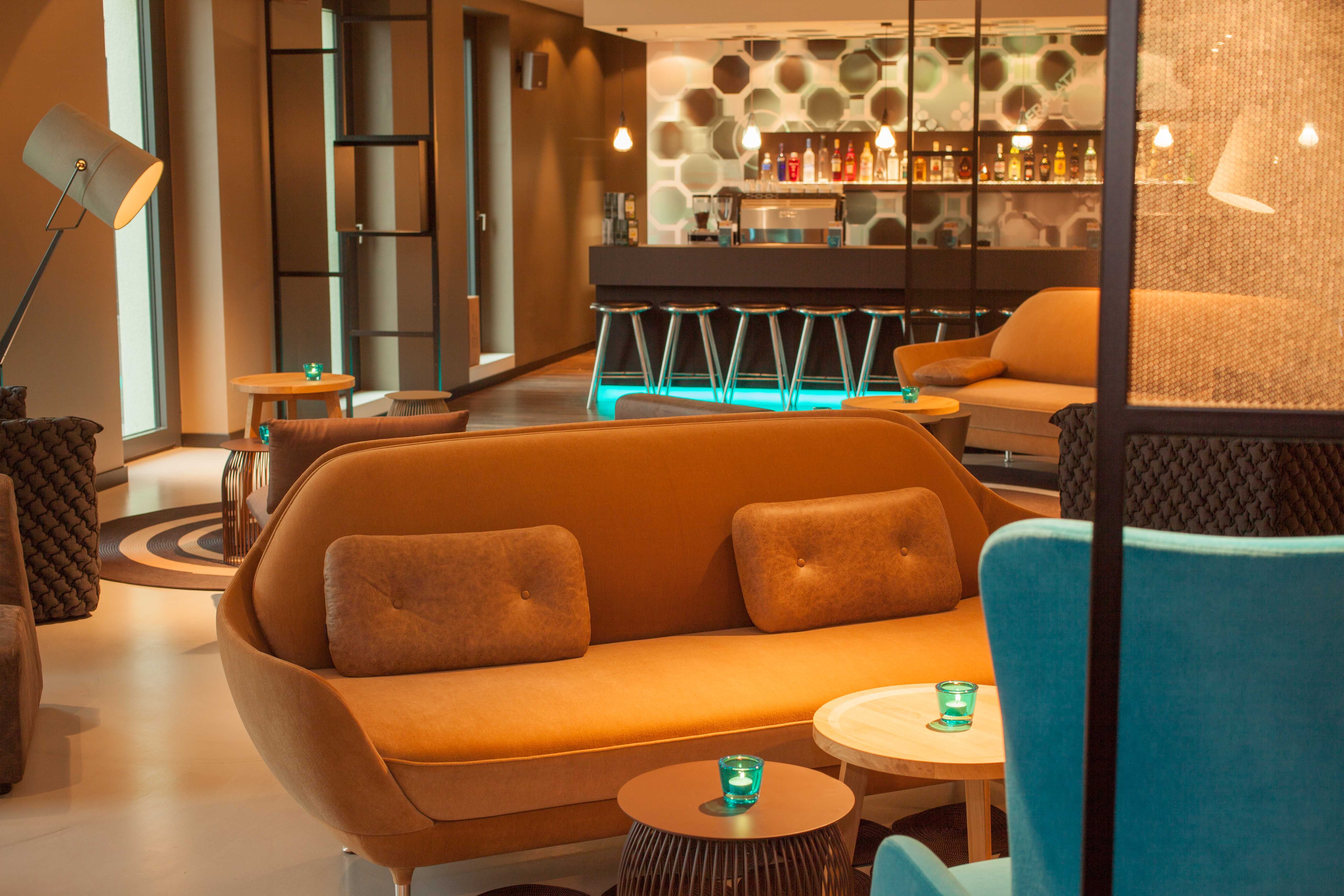 Hotel Berlin Potsdamer Platz Motel One Lounge mit Sesseln und Sofas sowie Bar im Hintergrund