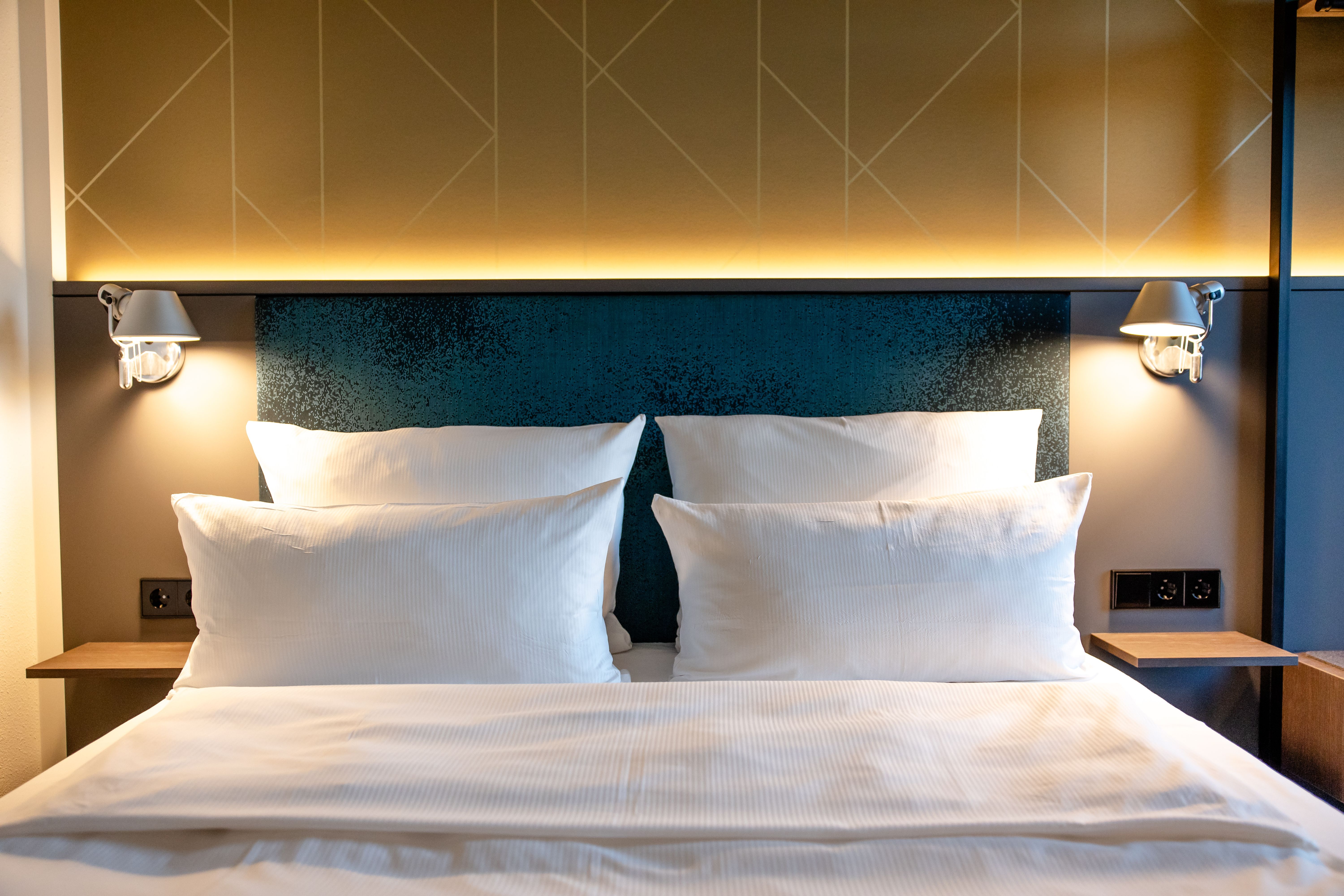 Hotel Berlin-Potsdamer Platz Motel One Modernes Doppelzimmer mit großem, gemütlichem Bett, weichen weißen Kissen und Bettwäsche. 