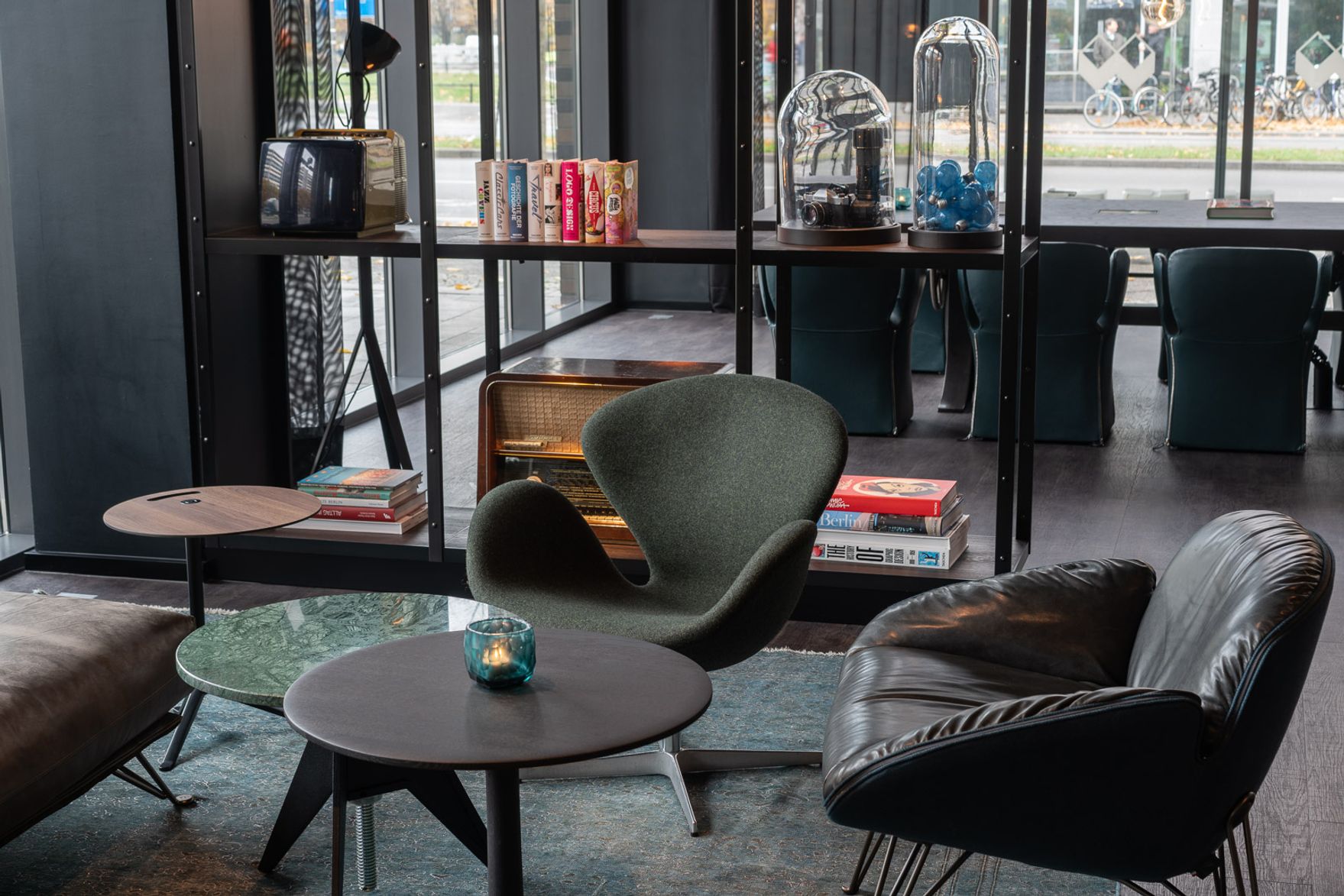 Hotel Berlin Spittelmarkt Motel One lichtdurchflutete Lounge mit bodentiefen Fenstern sowie Blick auf eine Sitzgruppe mit mehreren Sesseln und einem Beistelltisch