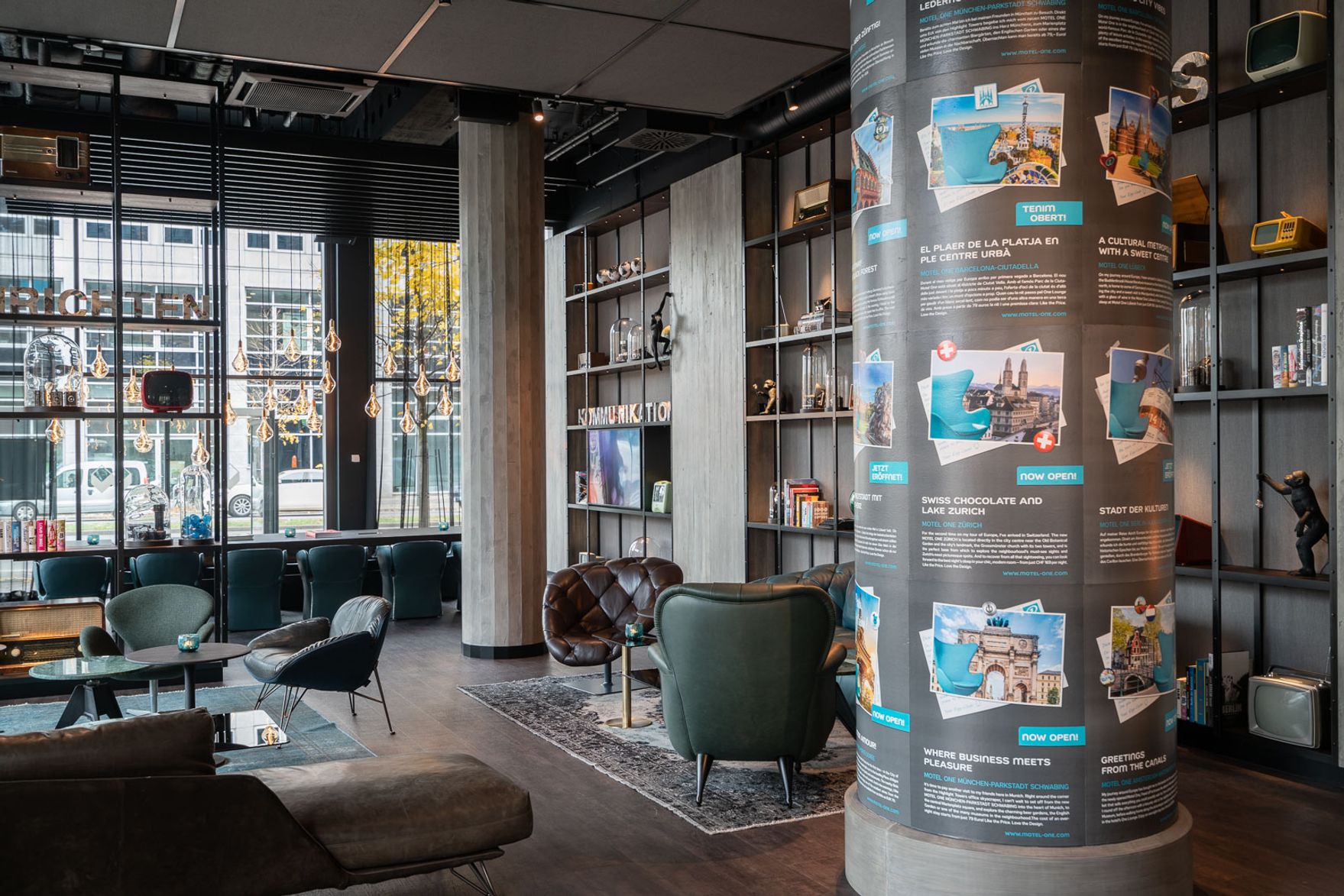 Hotel Berlin Spittelmarkt Motel One helle Lounge mit Sitzgelegenheiten sowie große Litfasssäule im Raum