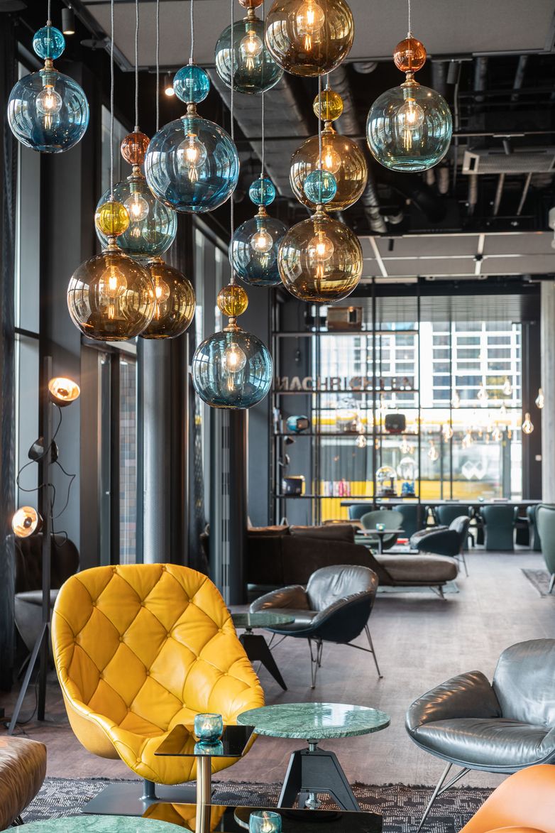 Hotel Berlin Spittelmarkt Motel One helle Lounge mit mehreren Sitzgelegenheiten sowie gelbem Sessel im Vordergrund