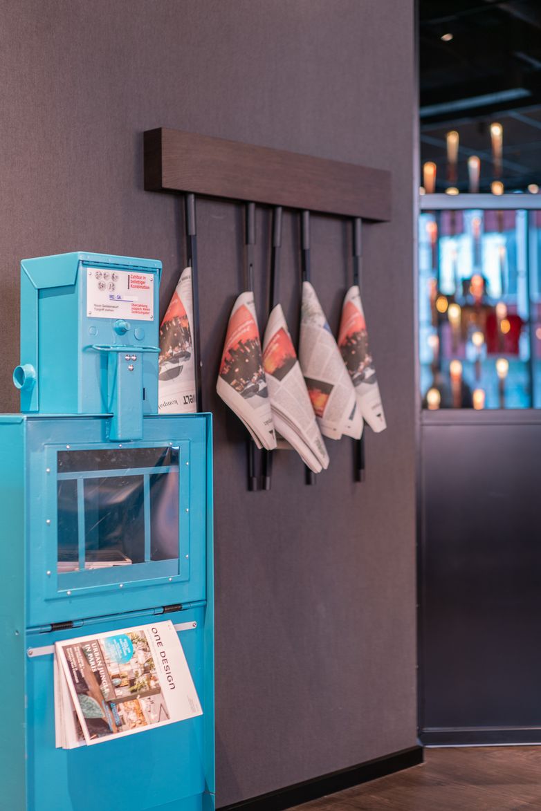Designhotel Berlin Spittelmarkt Motel One Zeitungskasten in blau sowie Zeitungen, die von der Wand hängen