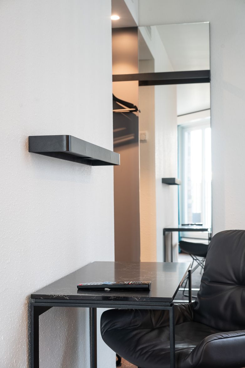 Hotel Berlin Spittelmarkt Motel One helles Zimmer mit Blick auf einen Schreibtisch und Stuhl vor einem großen Spiegel