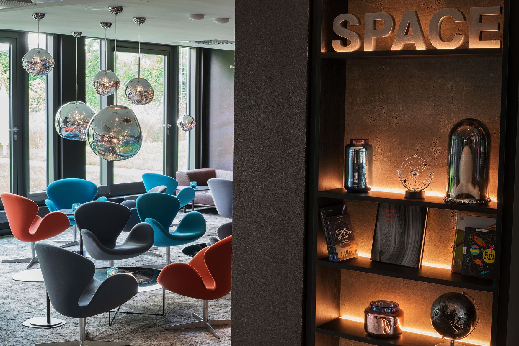 Hotel Berlin Tiergarten Motel One helle Lounge mit mehreren Sesseln und Beistelltischen sowie bodentiefe Fenster mit Aussicht ins Grüne