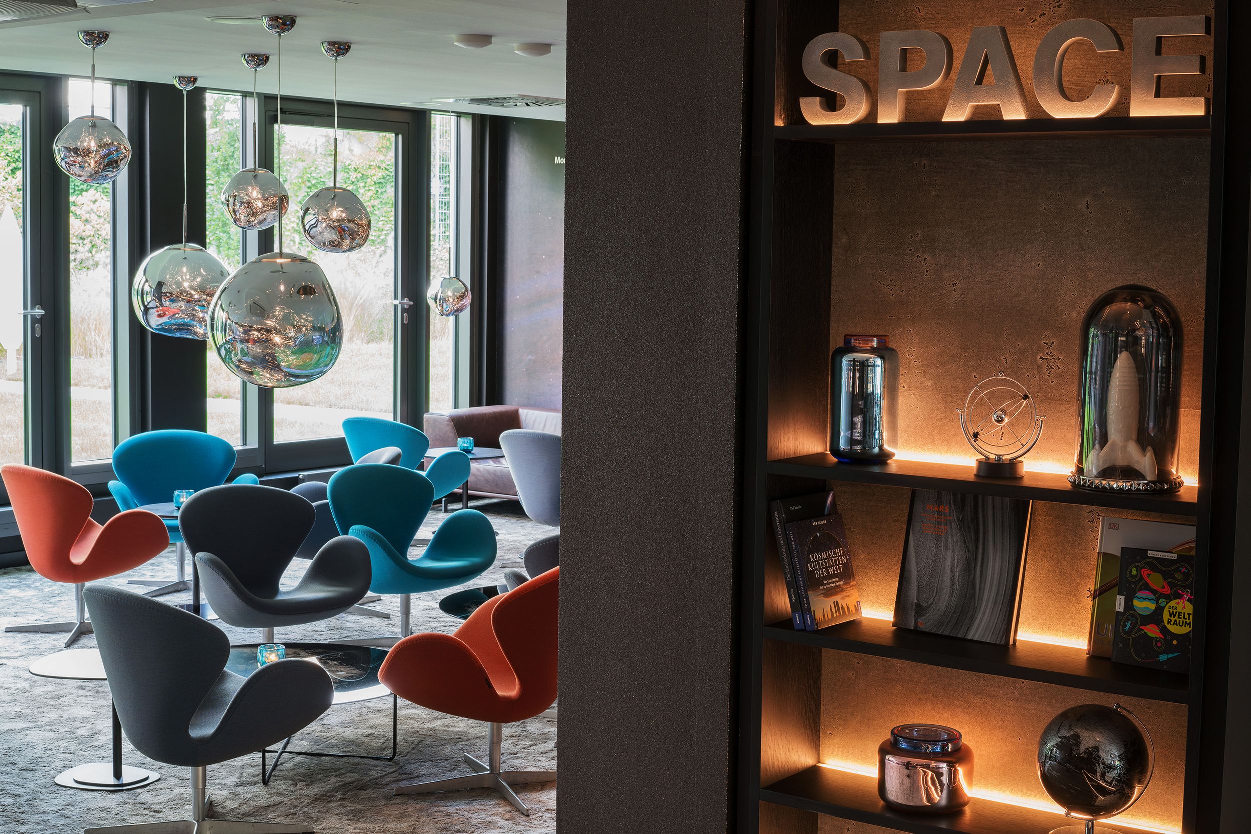 Hotel Berlin Tiergarten Motel One helle Lounge mit mehreren Sesseln und Beistelltischen sowie bodentiefe Fenster mit Aussicht ins Grüne