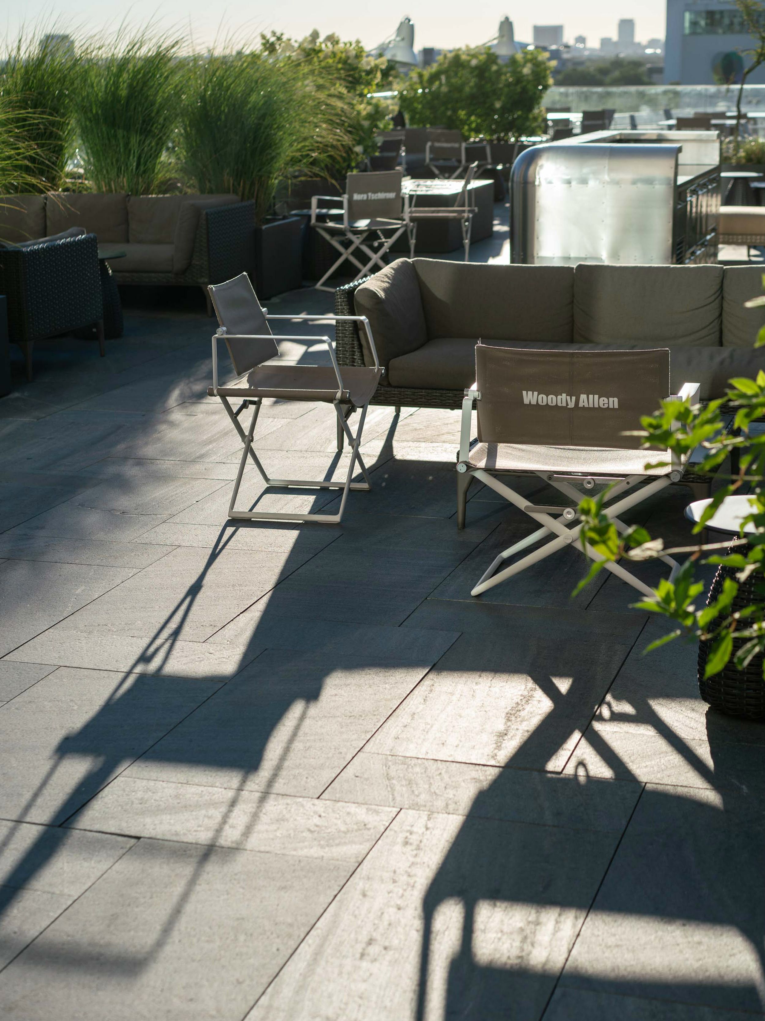 hotel Berlin Upper West Motel One sunny rooftop terrace with several lounge chairs and a view over the city