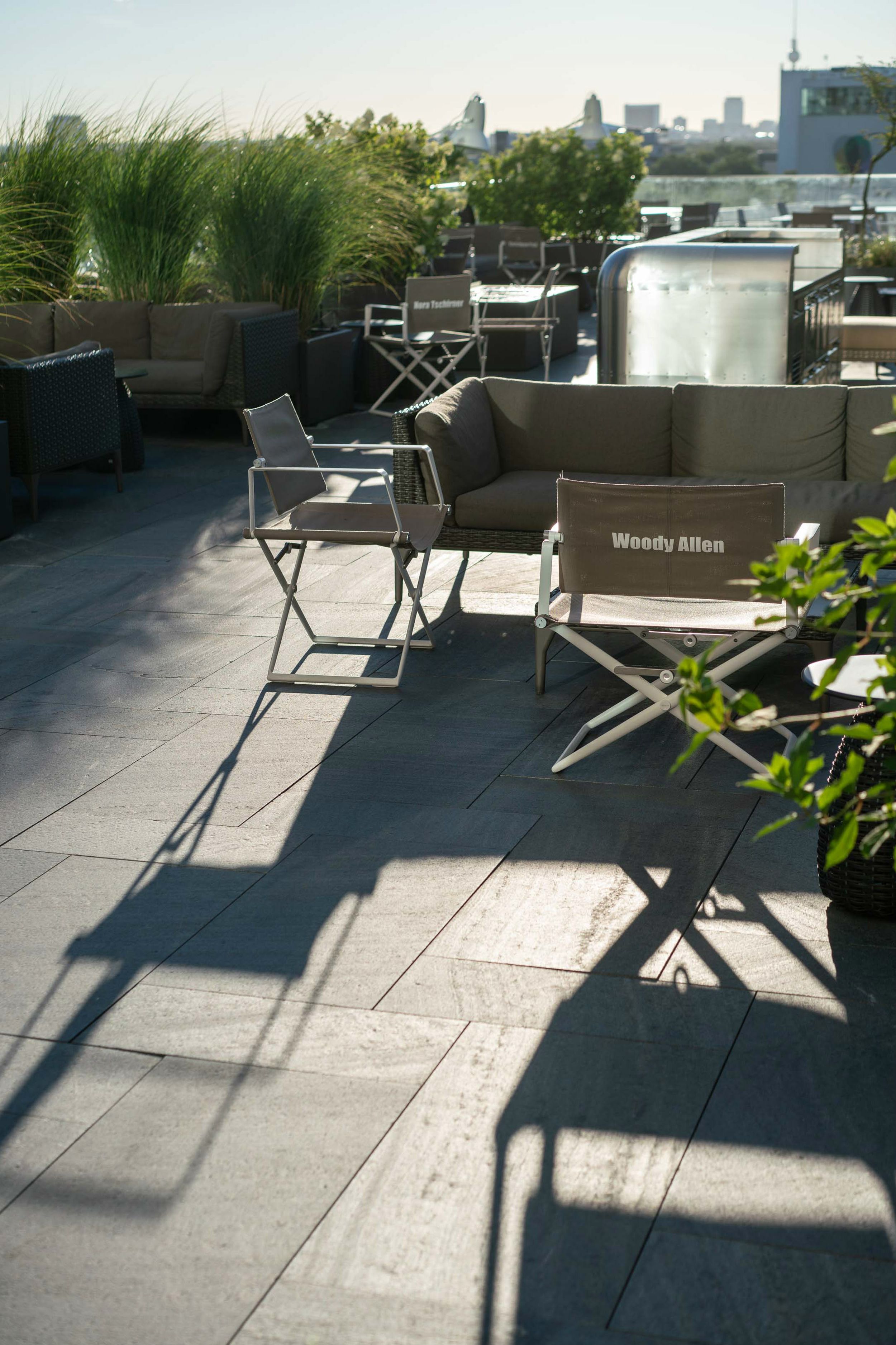 Hotel Berlin Upper West Motel One sonnige Dachterrasse mit mehreren Loungemöbeln und Blick über die Stadt