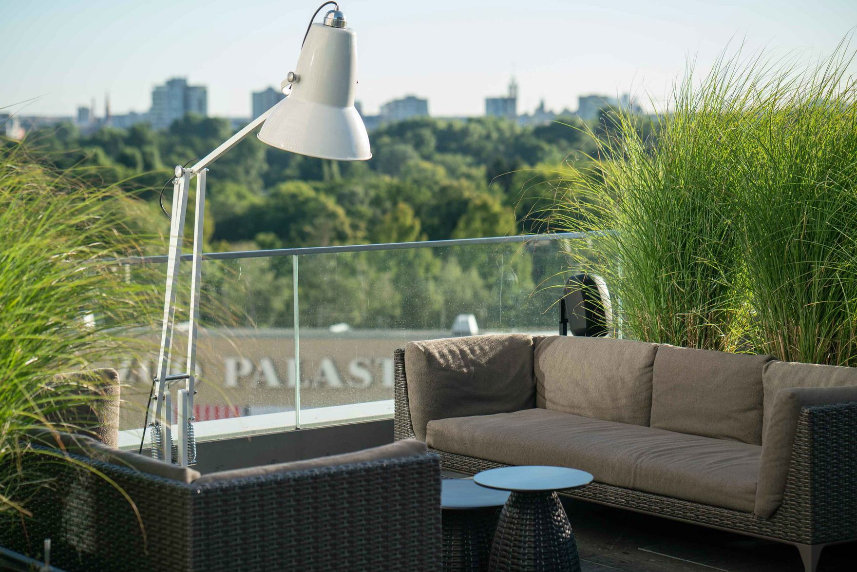 Designhotel Berlin Upper West Motel One sonnige Dachterrasse mit Blick auf eine Loungeecke und vielen grünen Pflanzen 