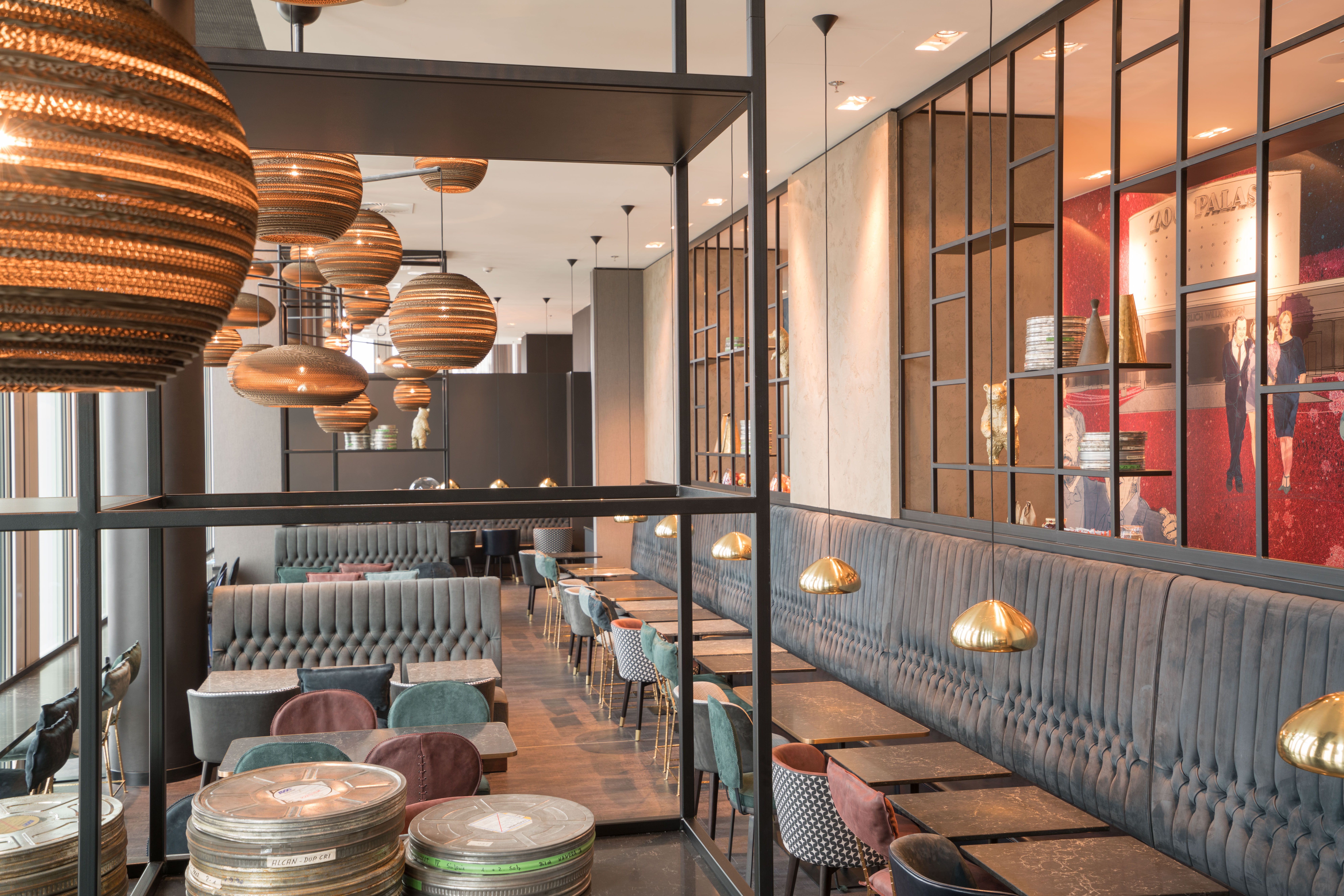 Designhotel Berlin Upper West Motel One heller Frühstücksraum mit mehreren Tischen und Stühlen