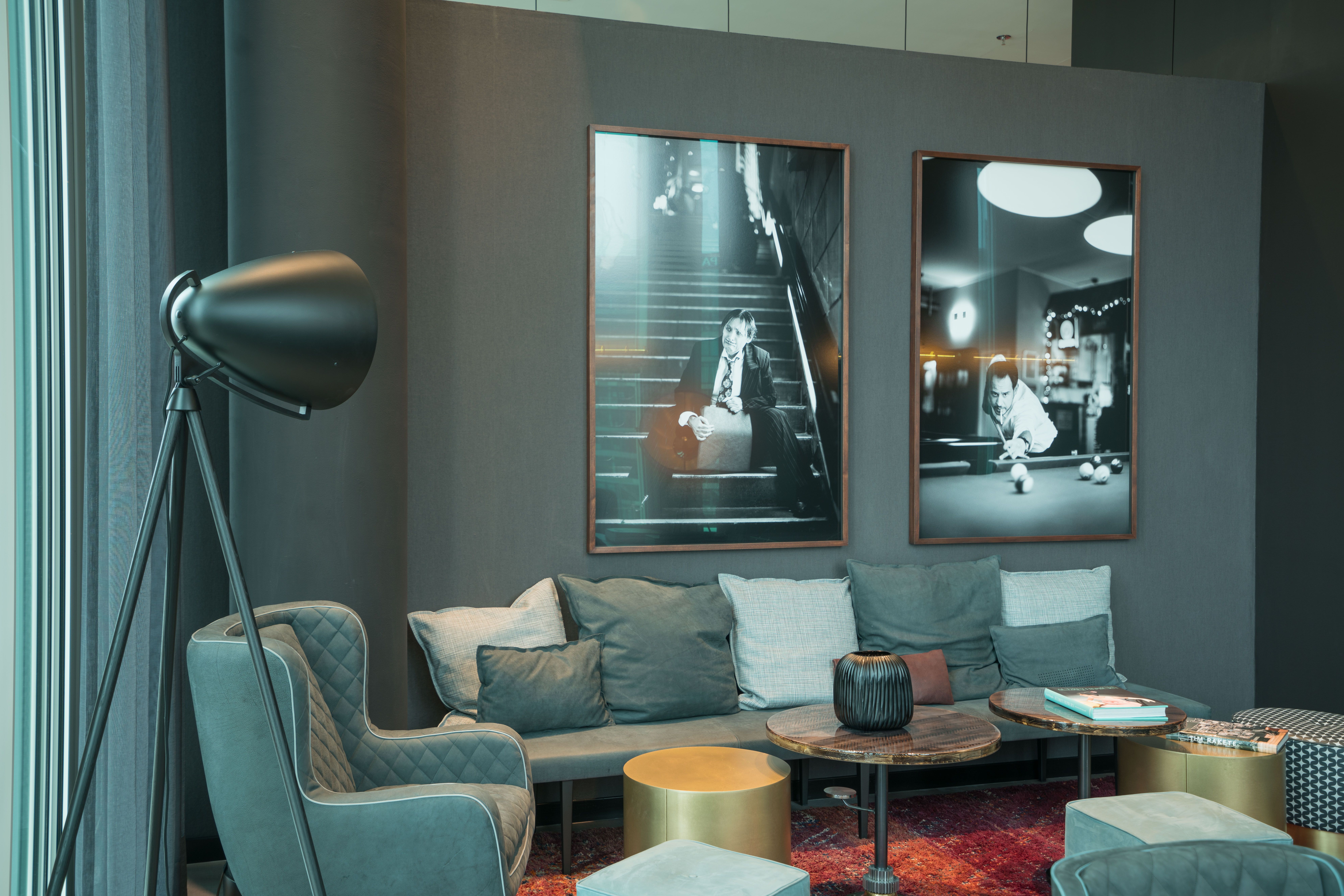 Designhotel Berlin Upper West Motel One Sitzecke in der Lounge mit Sesseln und Beistelltischen sowie zwei Bildern an der Wand