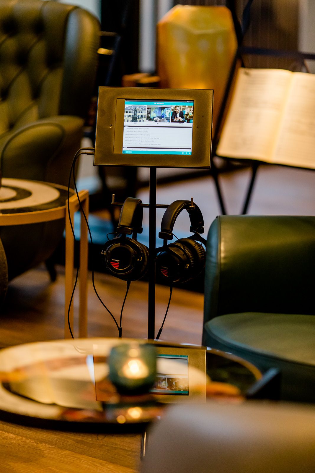 Hotel Bonn Beethoven Motel One Nahaufnahme auf Tablet mit mehreren Auswahlmöglichkeiten sowie zwei Kopfhörer