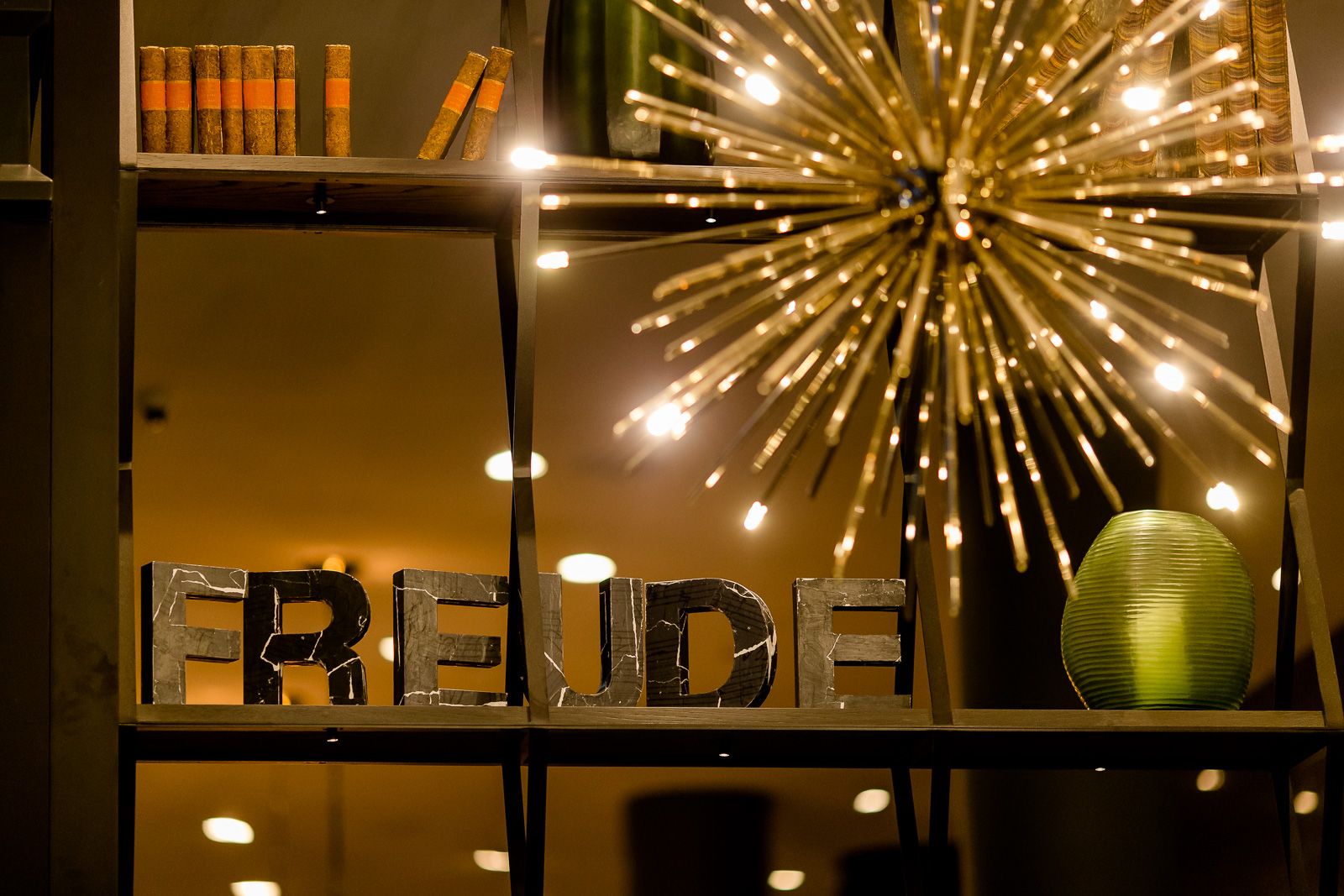 Hotel Bonn Beethoven Motel One Blick auf ein offenes Regal mit Dekoration sowie eine große Deckenleuchte